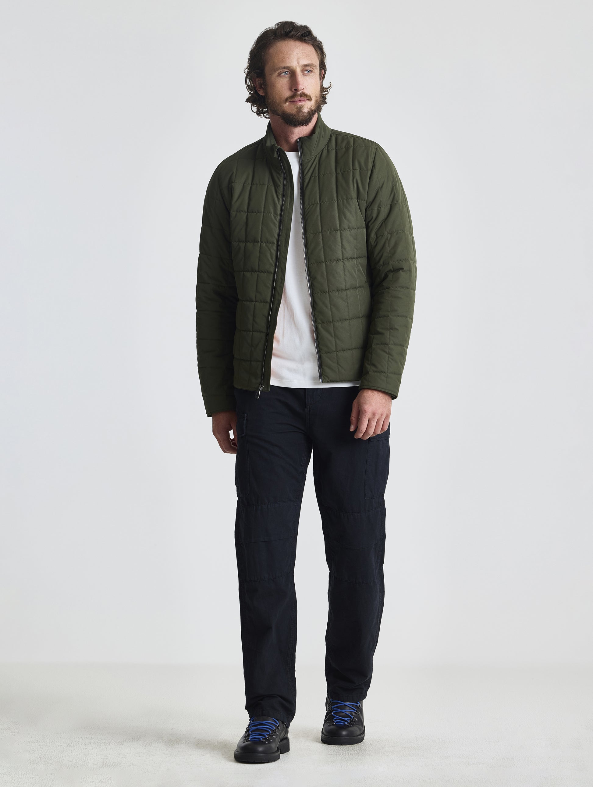 Front full-body view of man wearing unzipped Alto Jacket 2.0 in Forest Green from AETHER Apparel.