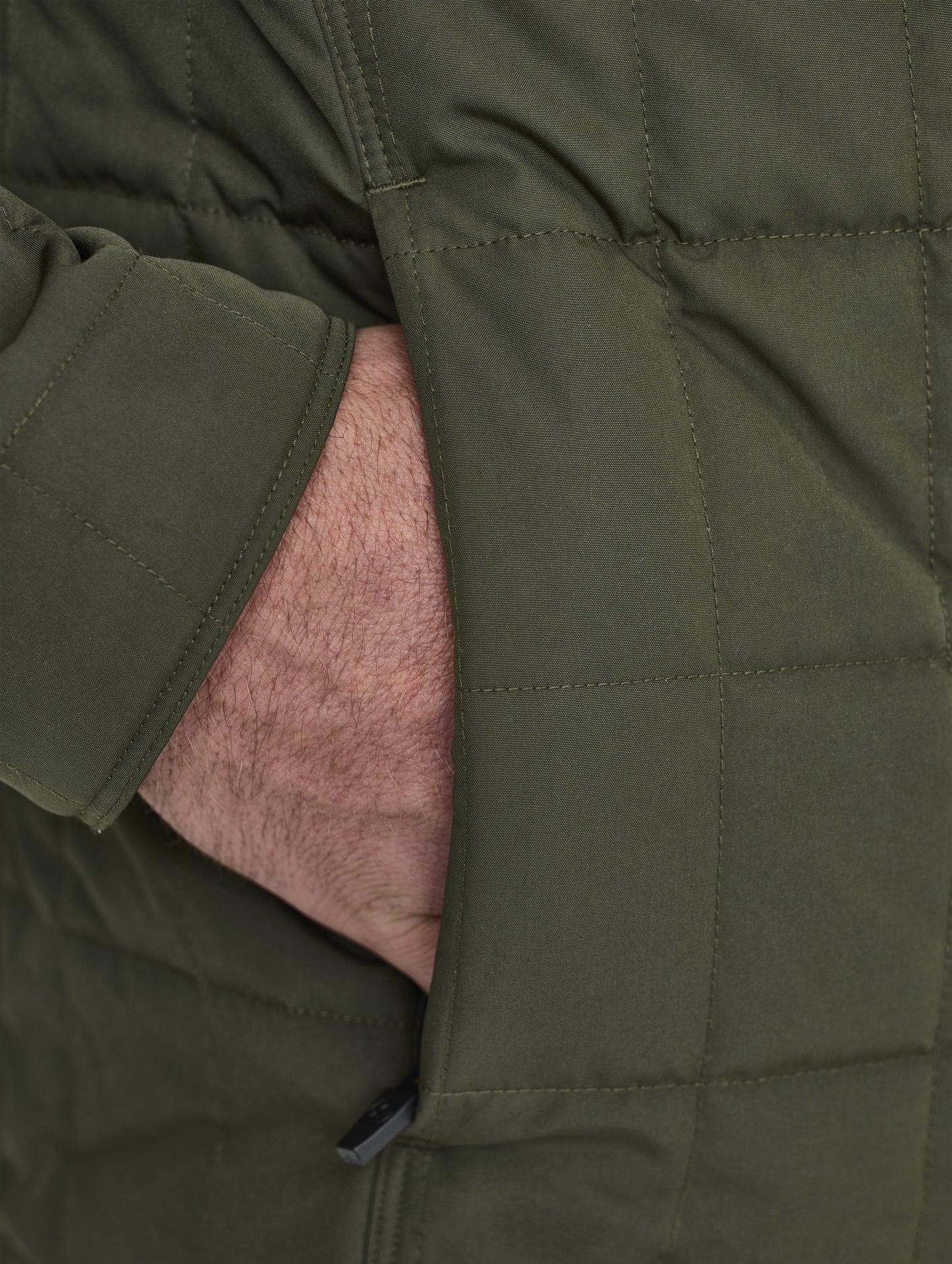 Closeup detailed view of the concealed, zippered hand pockets on the Alto Jacket 2.0 in Forest Green from AETHER Apparel.