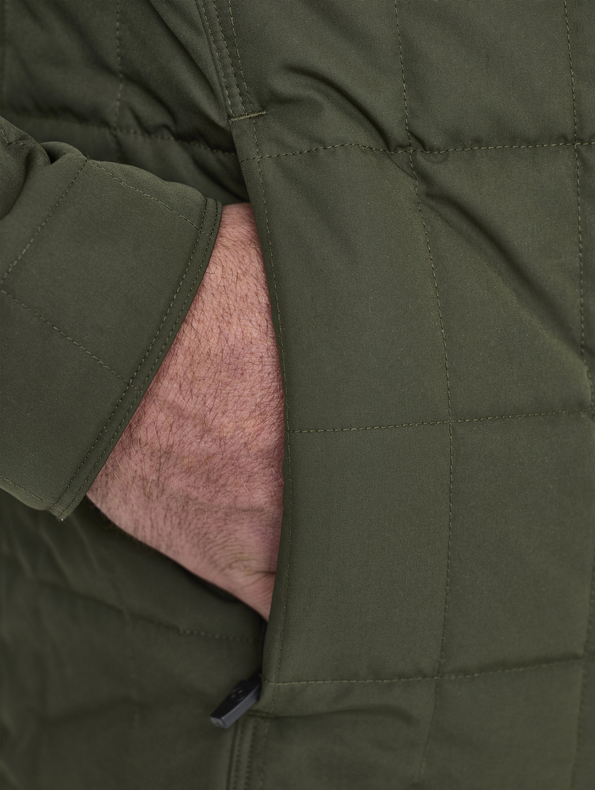 Closeup detailed view of the concealed, zippered hand pockets on the Alto Jacket 2.0 in Forest Green from AETHER Apparel.