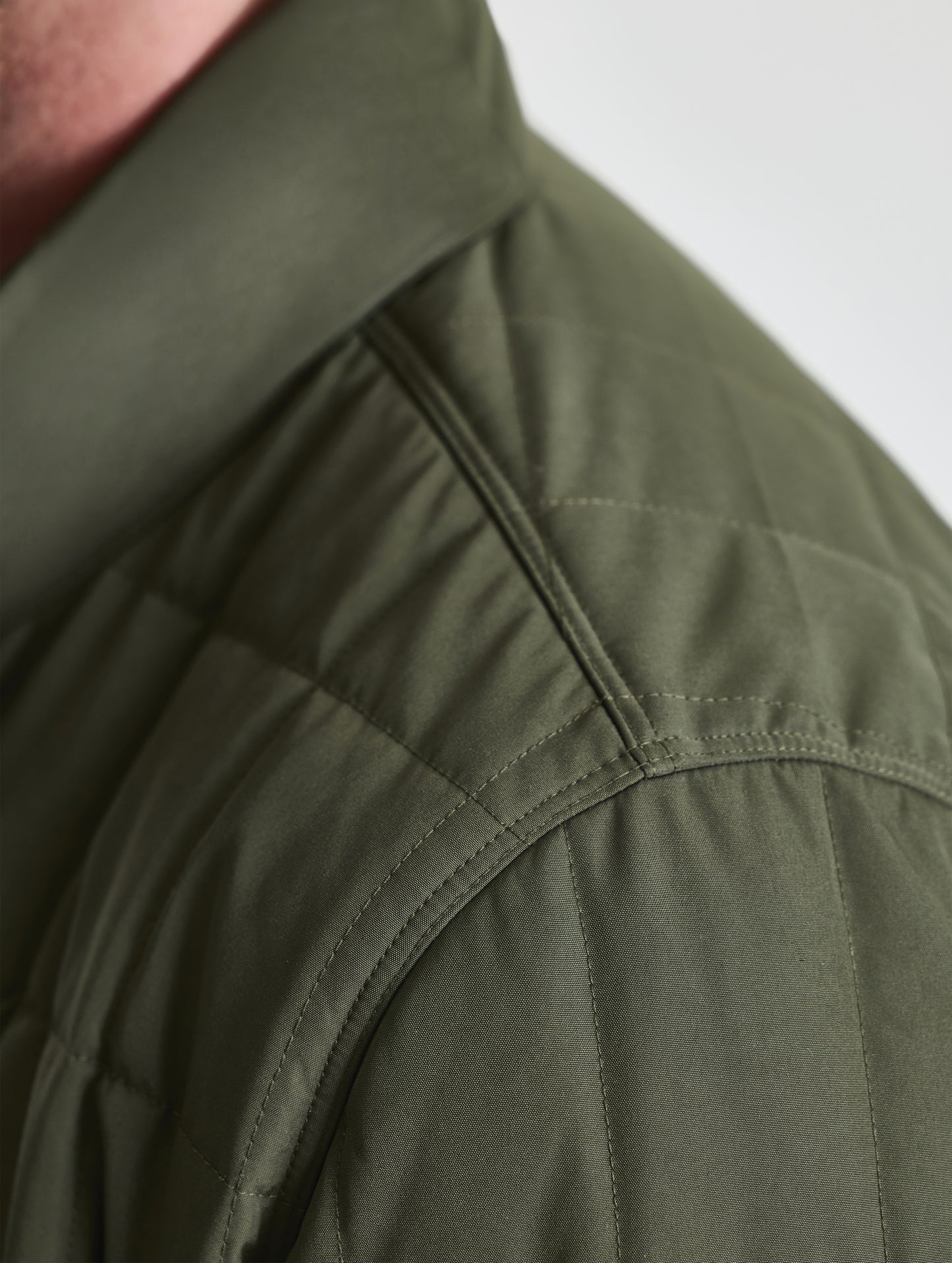 Closeup detailed view of the shoulder of the Alto Jacket 2.0 in Forest Green from AETHER Apparel.