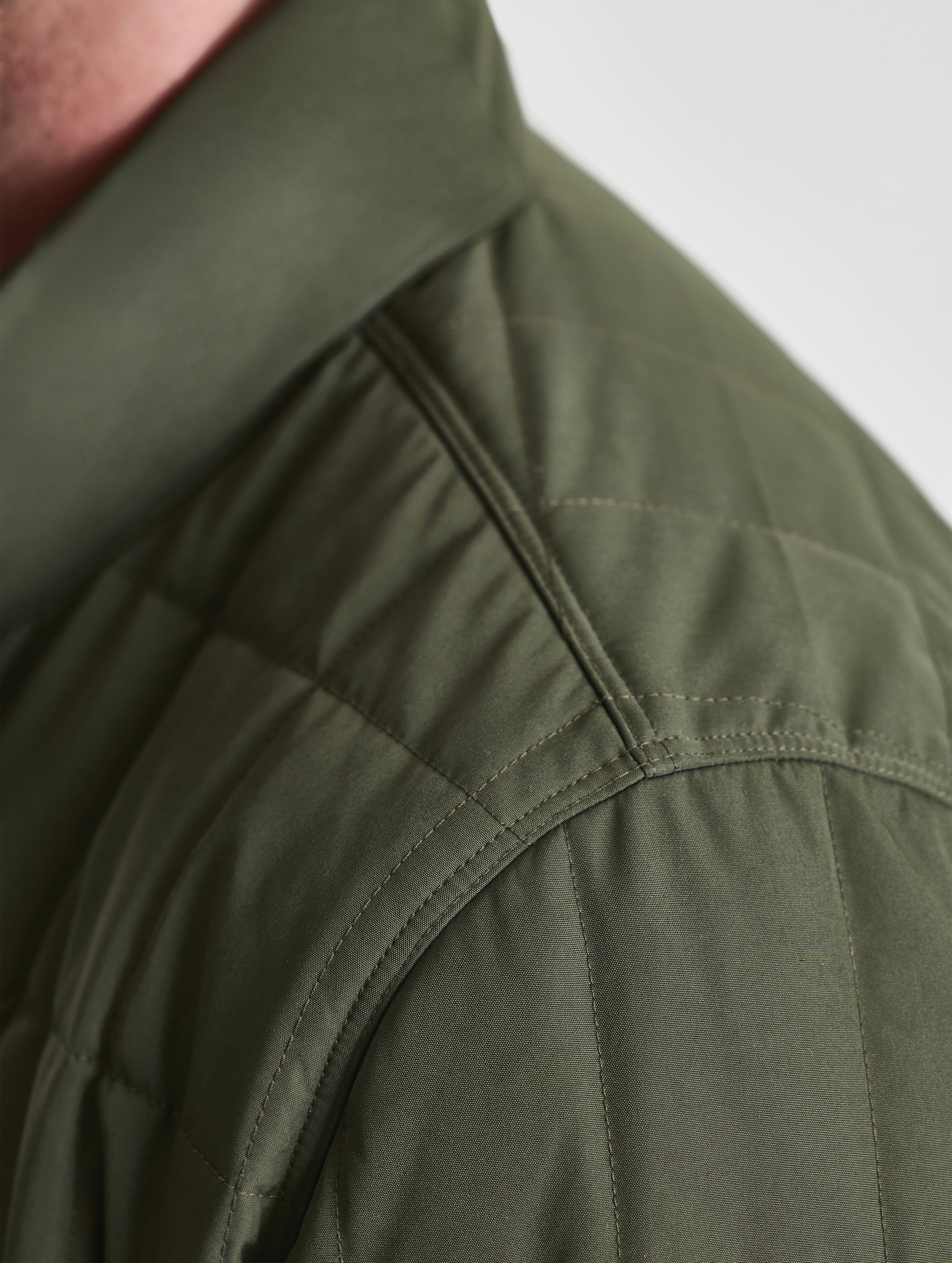 Closeup detailed view of the shoulder of the Alto Jacket 2.0 in Forest Green from AETHER Apparel.