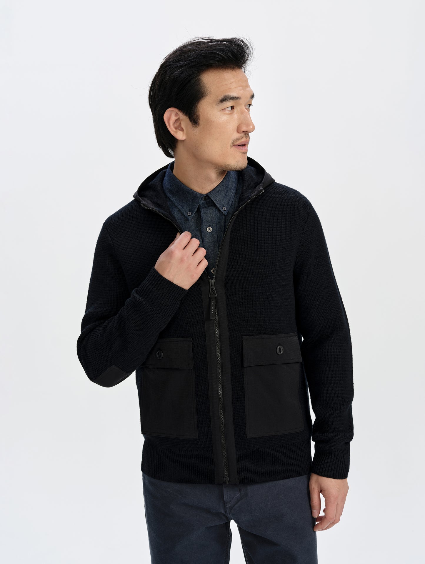 Front upper-body view of man wearing the Benson Full-Zip Sweater in Onyx Black from AETHER Apparel.