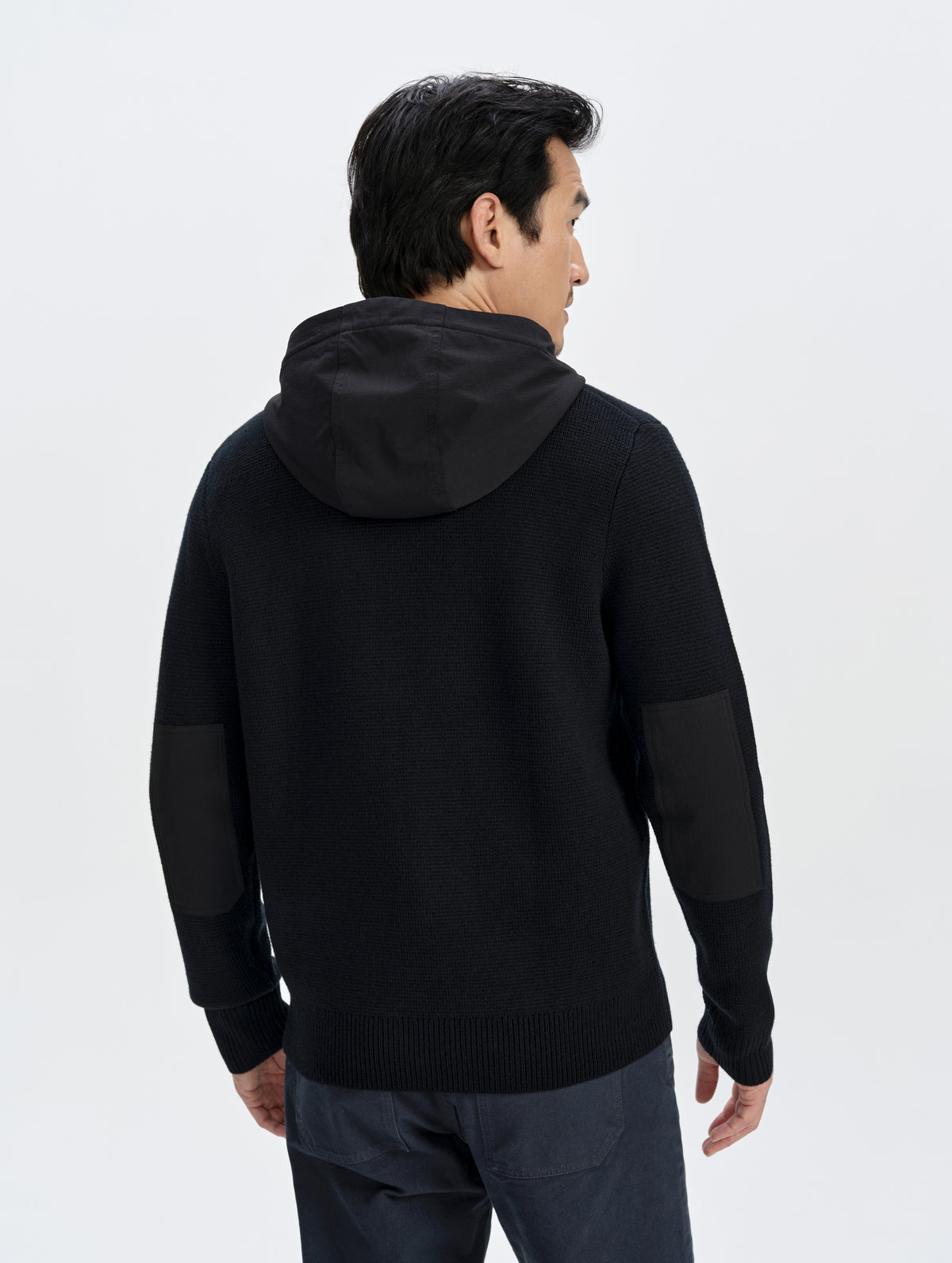 Rear upper-body view of man wearing the Benson Full-Zip Sweater in Onyx Black from AETHER Apparel.