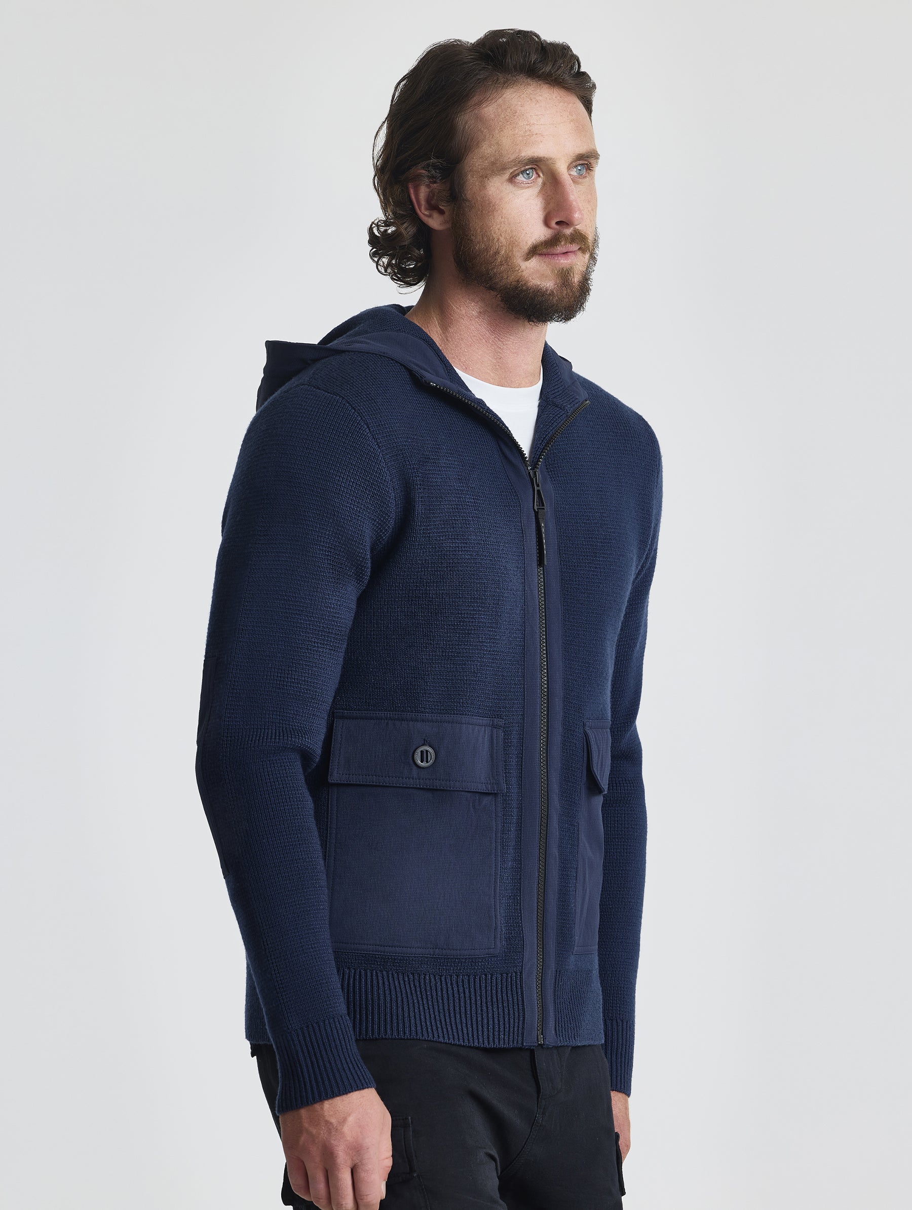 Angled front view of man wearing Full-Zip Sweater in Total Eclipse dark blue from AETHER Apparel.