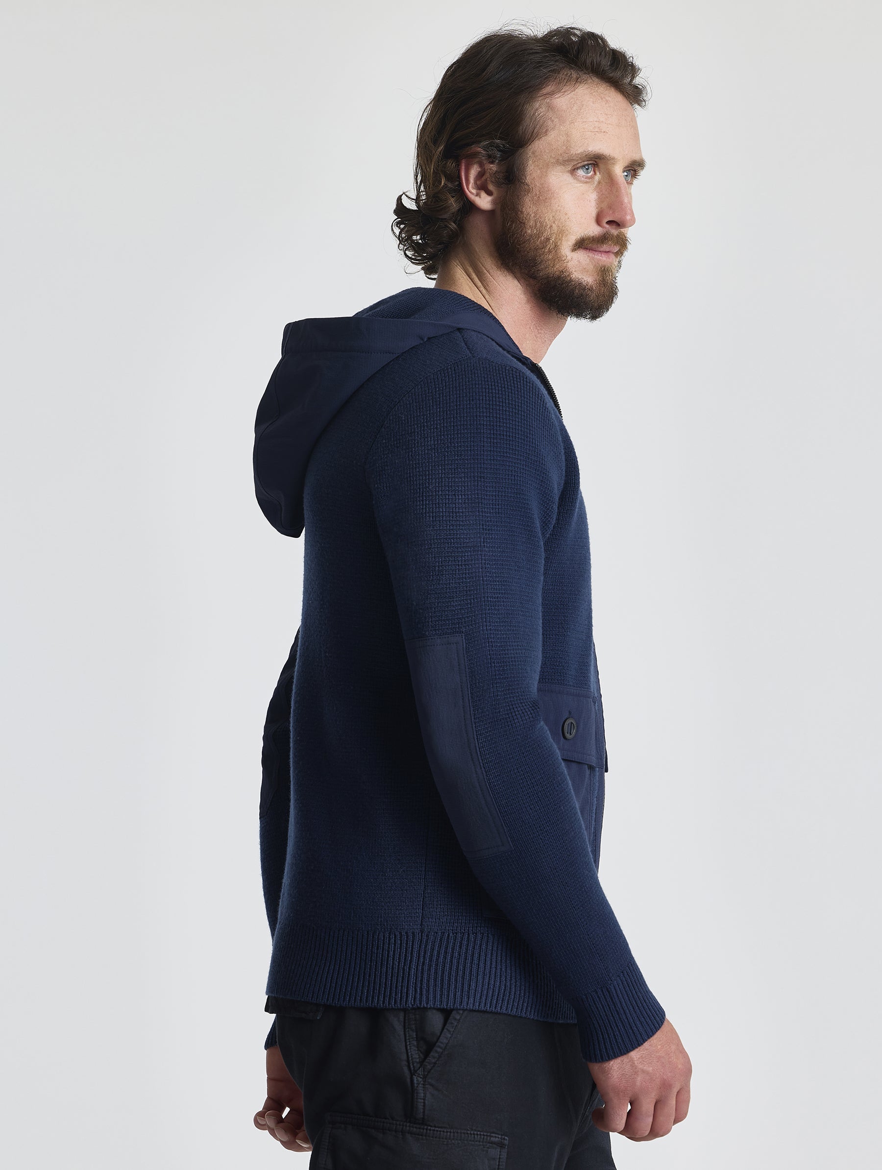 Right profile of man wearing Benson Full-Zip Sweater in Total Eclipse dark blue from AETHER Apparel.