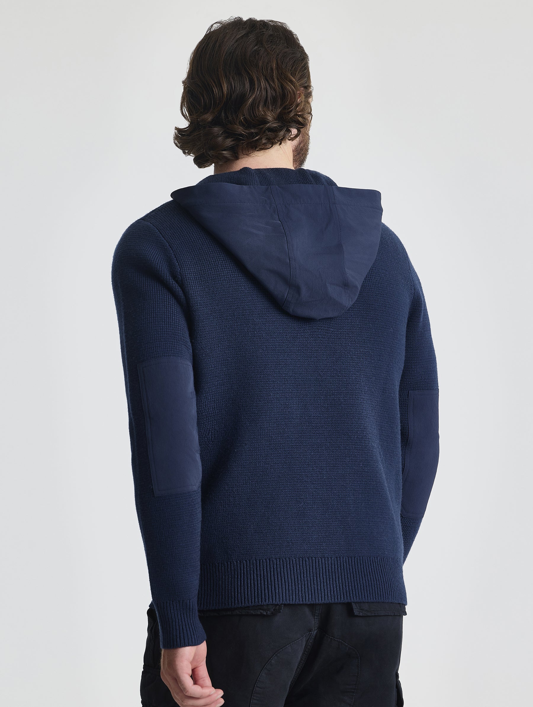 Rear upper body view of man wearing Benson Full-Zip Sweater in Total Eclipse dark blue from AETHER Apparel.