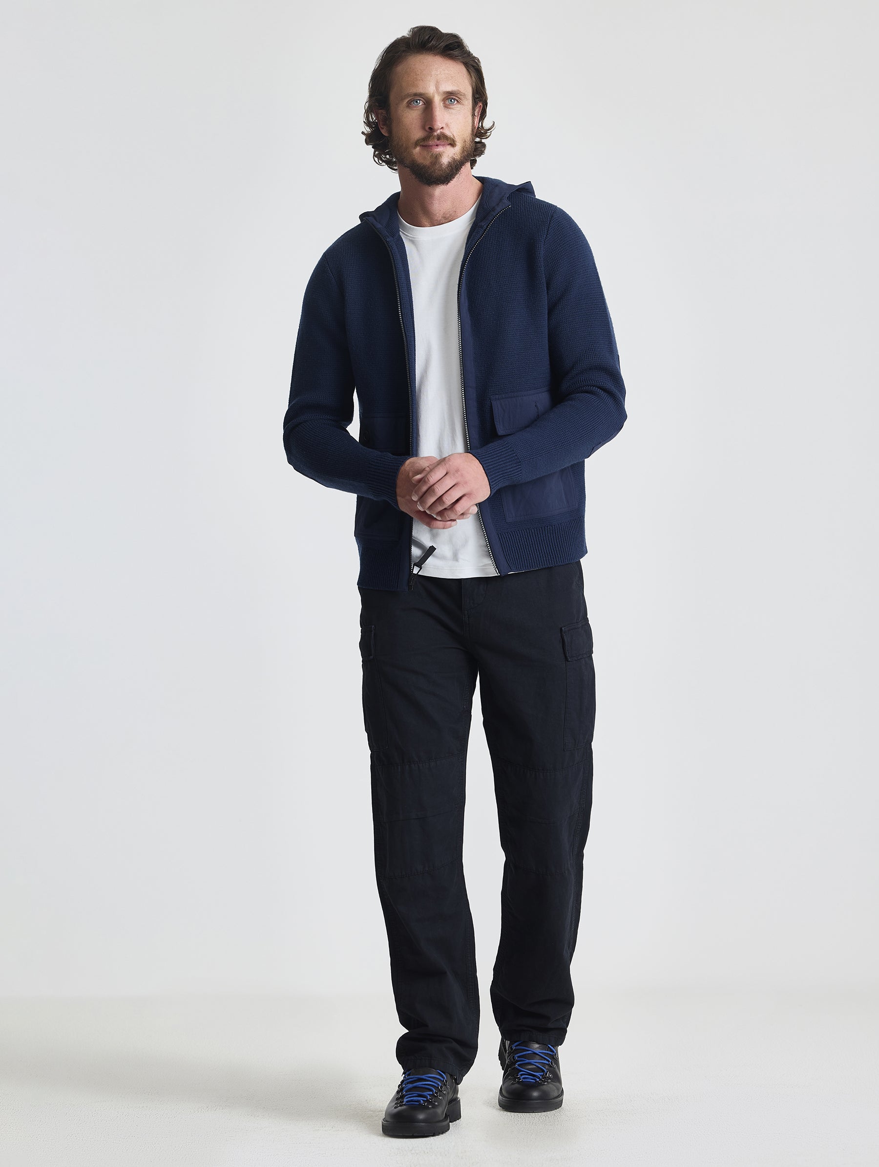 Full body view of man wearing Benson Full-Zip Sweater in Total Eclipse dark blue from AETHER Apparel.
