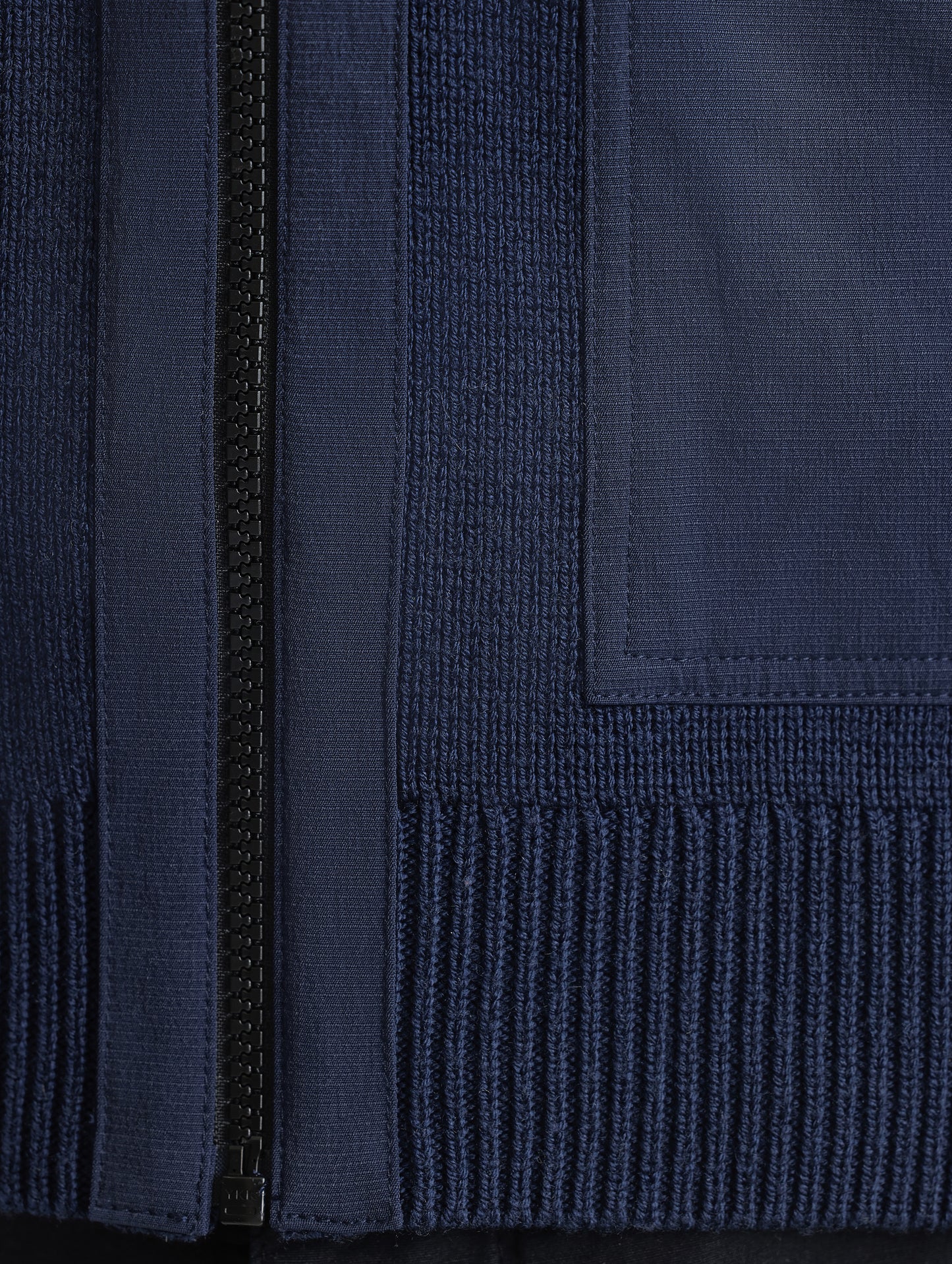 Closeup view of zipper and bottom hem of Benson Full-Zip Sweater in Total Eclipse dark blue from AETHER Apparel.