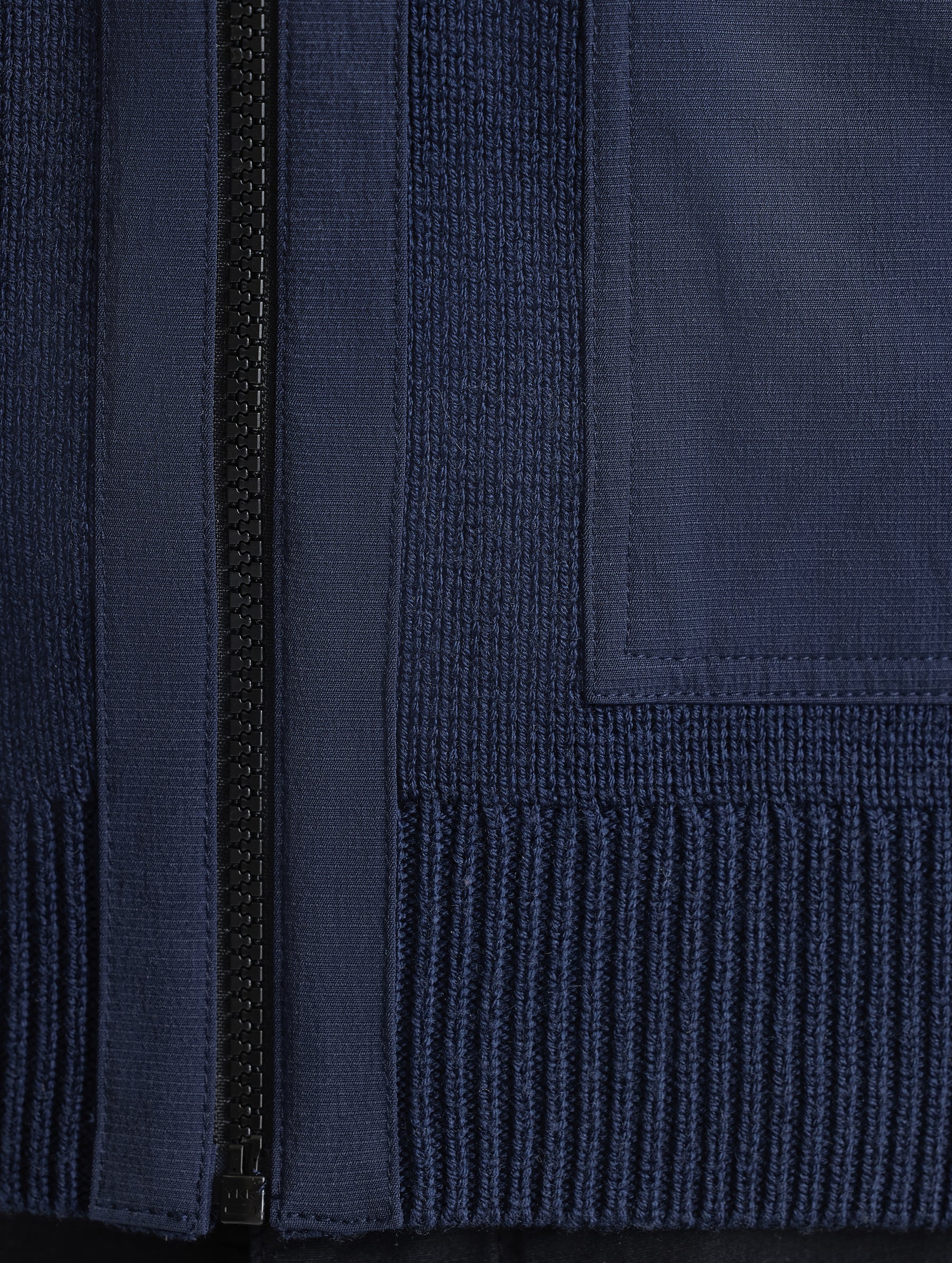 Closeup view of zipper and bottom hem of Benson Full-Zip Sweater in Total Eclipse dark blue from AETHER Apparel.