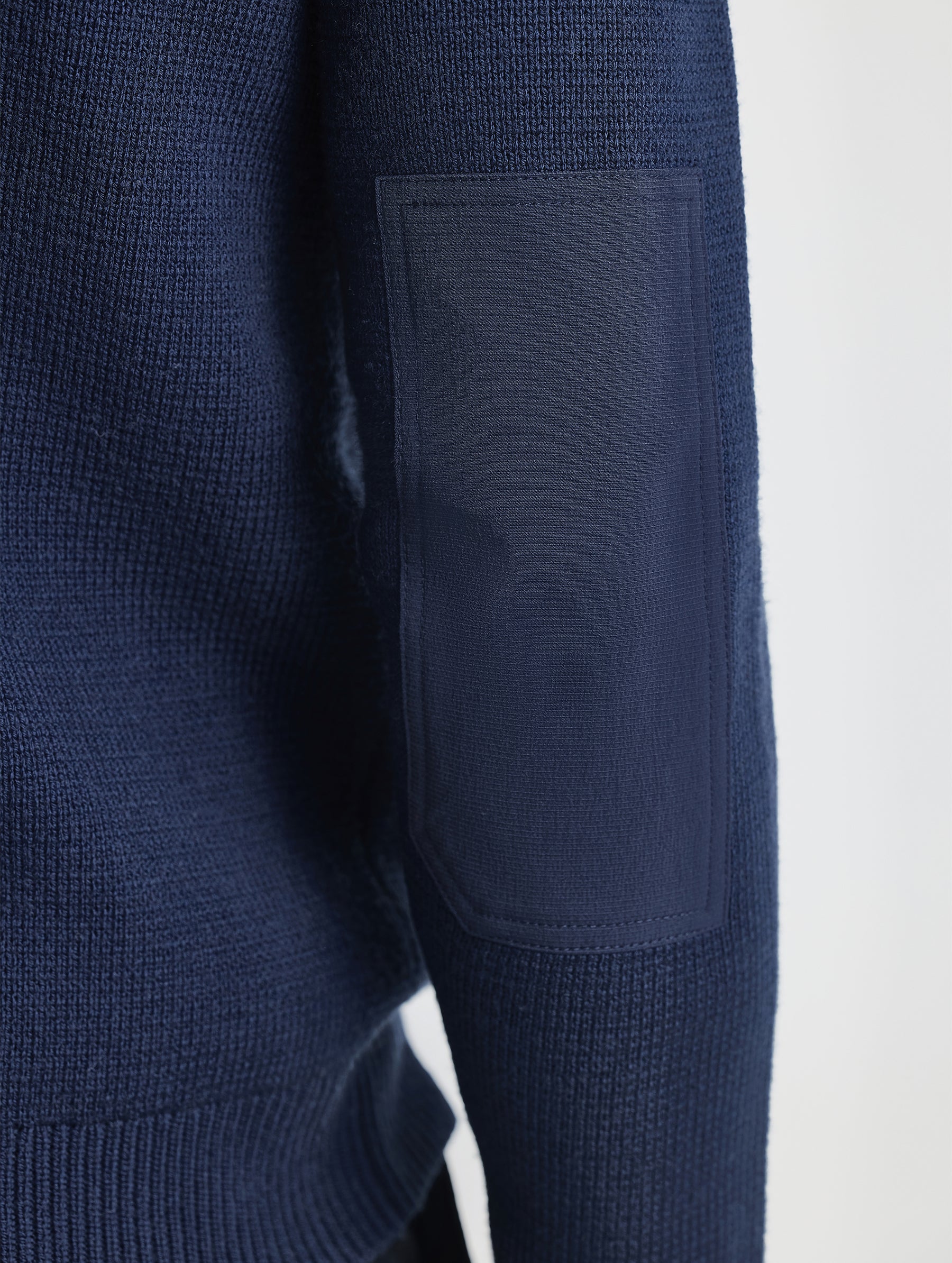 Rear closeup view of right elbow patch of Benson Full-Zip Sweater in Total Eclipse dark blue from AETHER Apparel.
