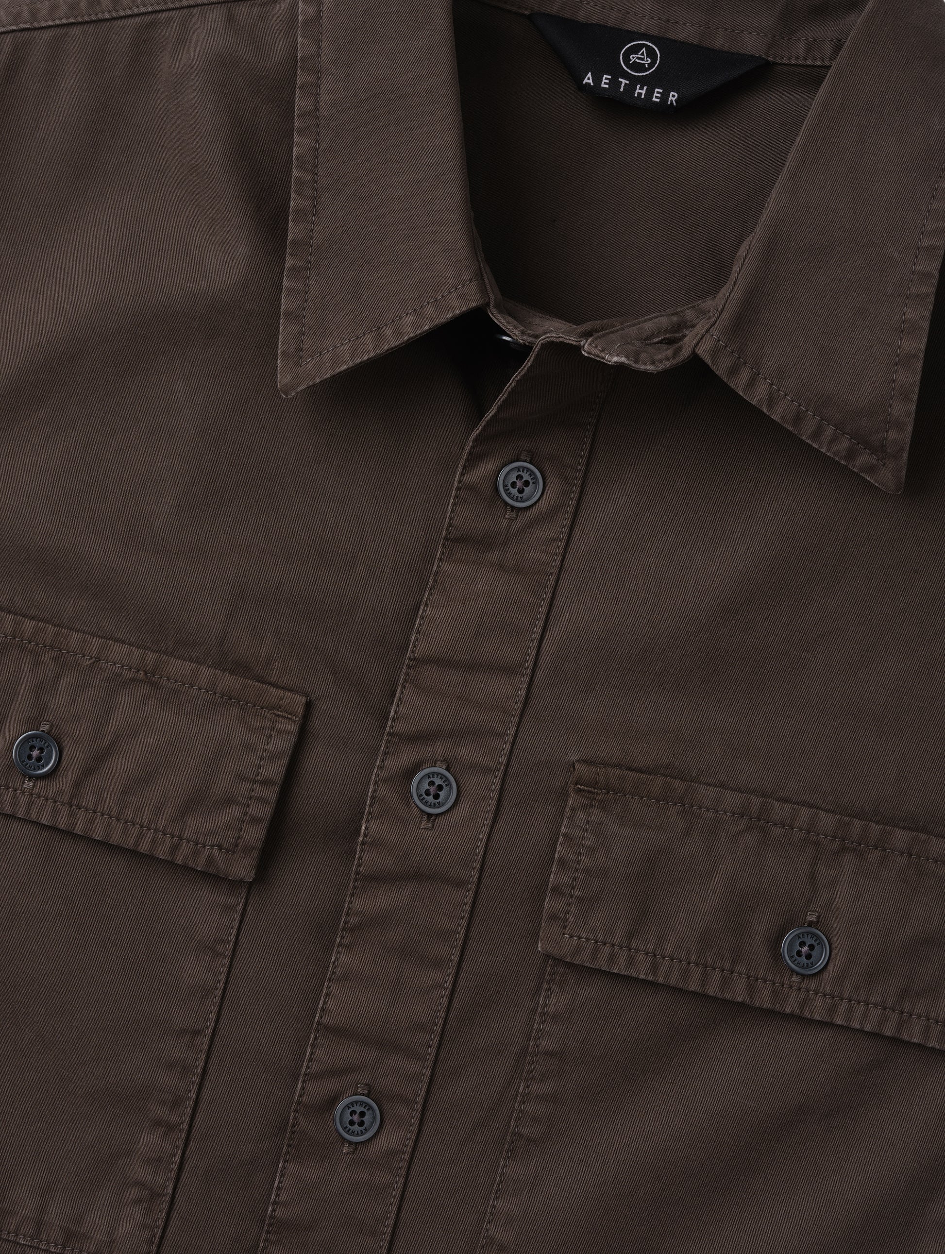 Closeup detailed view of the main center-front button closure and collar on the Caden Work Shirt in Ash Brown from AETHER Apparel.