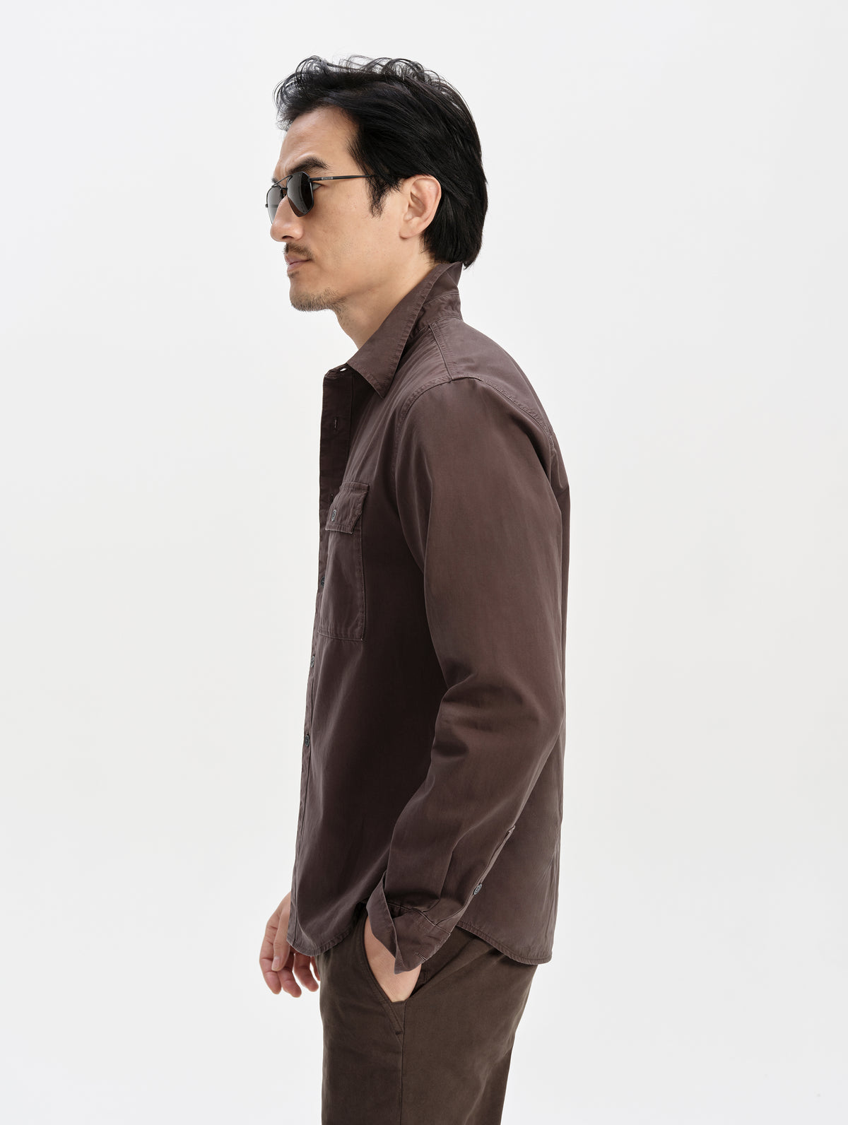Side profile upper-body view of man wearing the Caden Work Shirt in Ash Brown from AETHER Apparel.