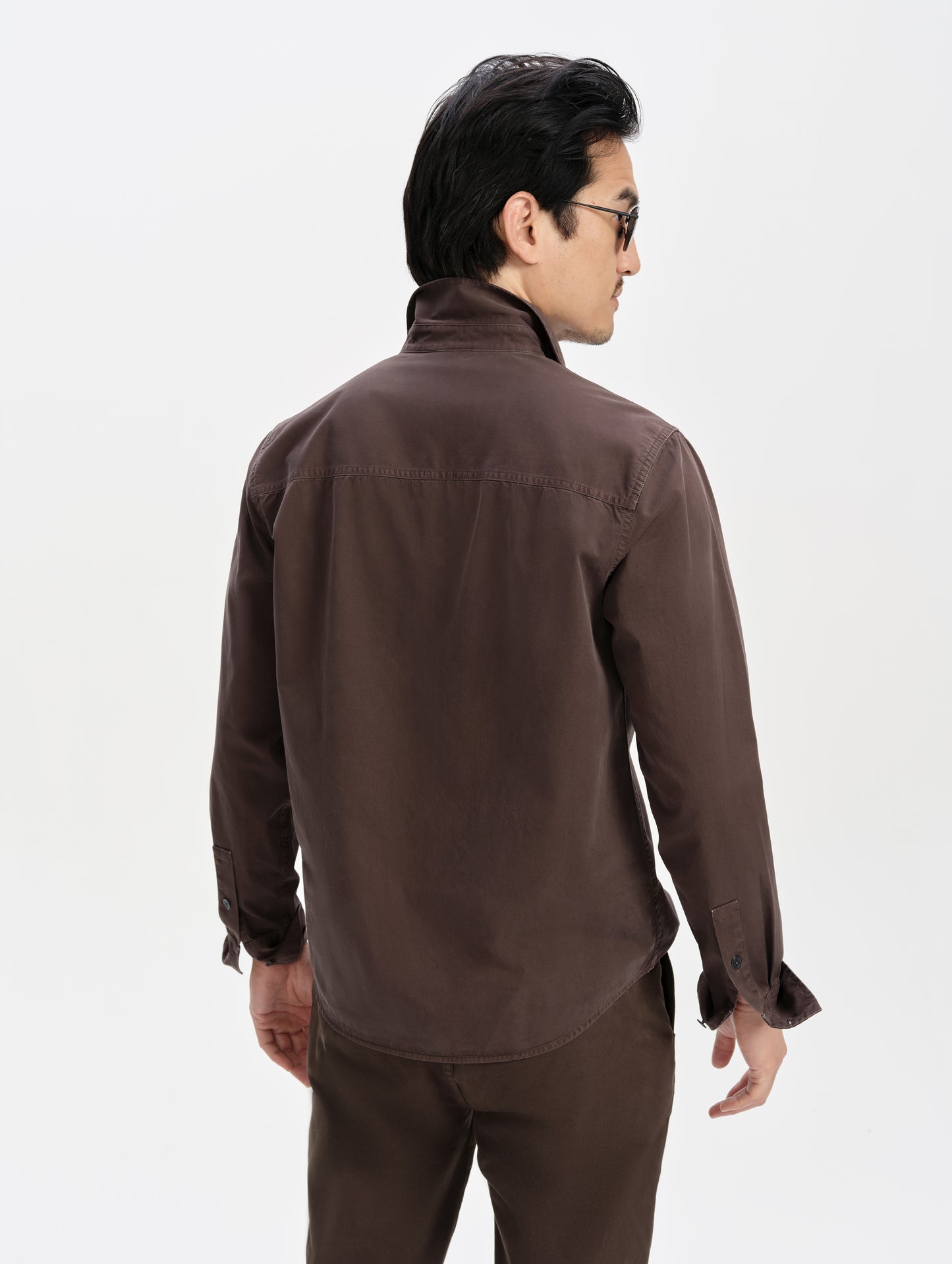 Rear upper-body view of man wearing the Caden Work Shirt in Ash Brown from AETHER Apparel.