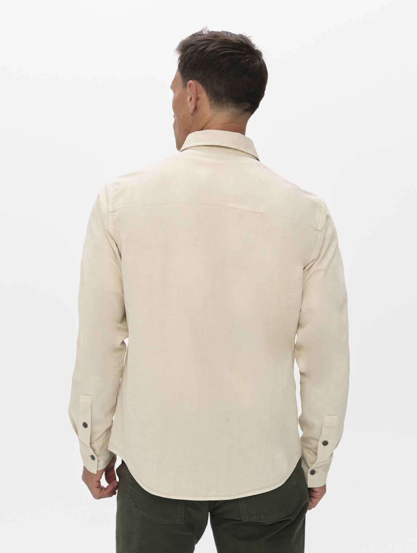 Rear upper-body view of man wearing the Caden Work Shirt in Bone from AETHER Apparel.
