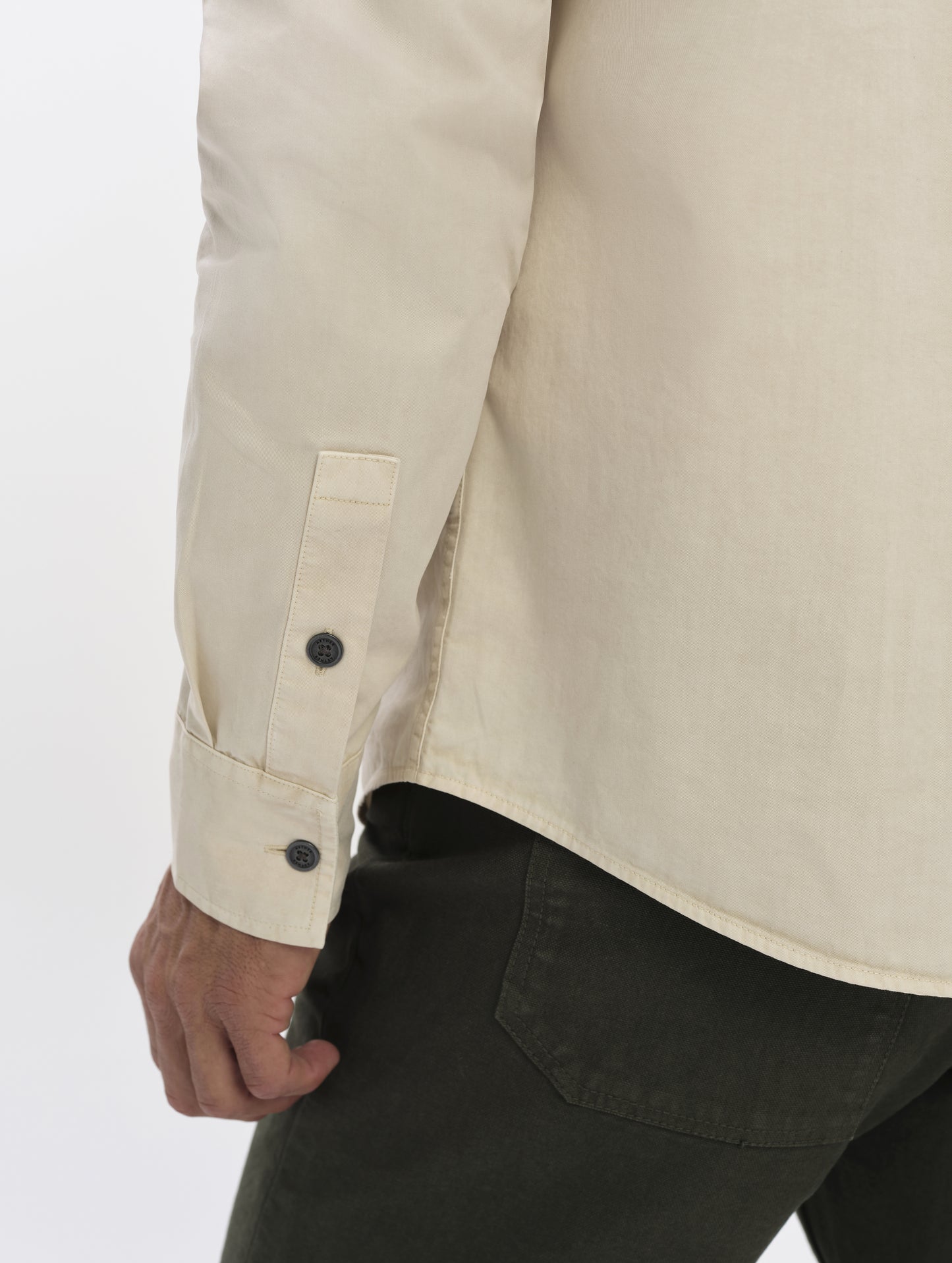 Closeup detailed view of the wrist cuffs and drop-tail hem on the Caden Work Shirt in Bone from AETHER Apparel.