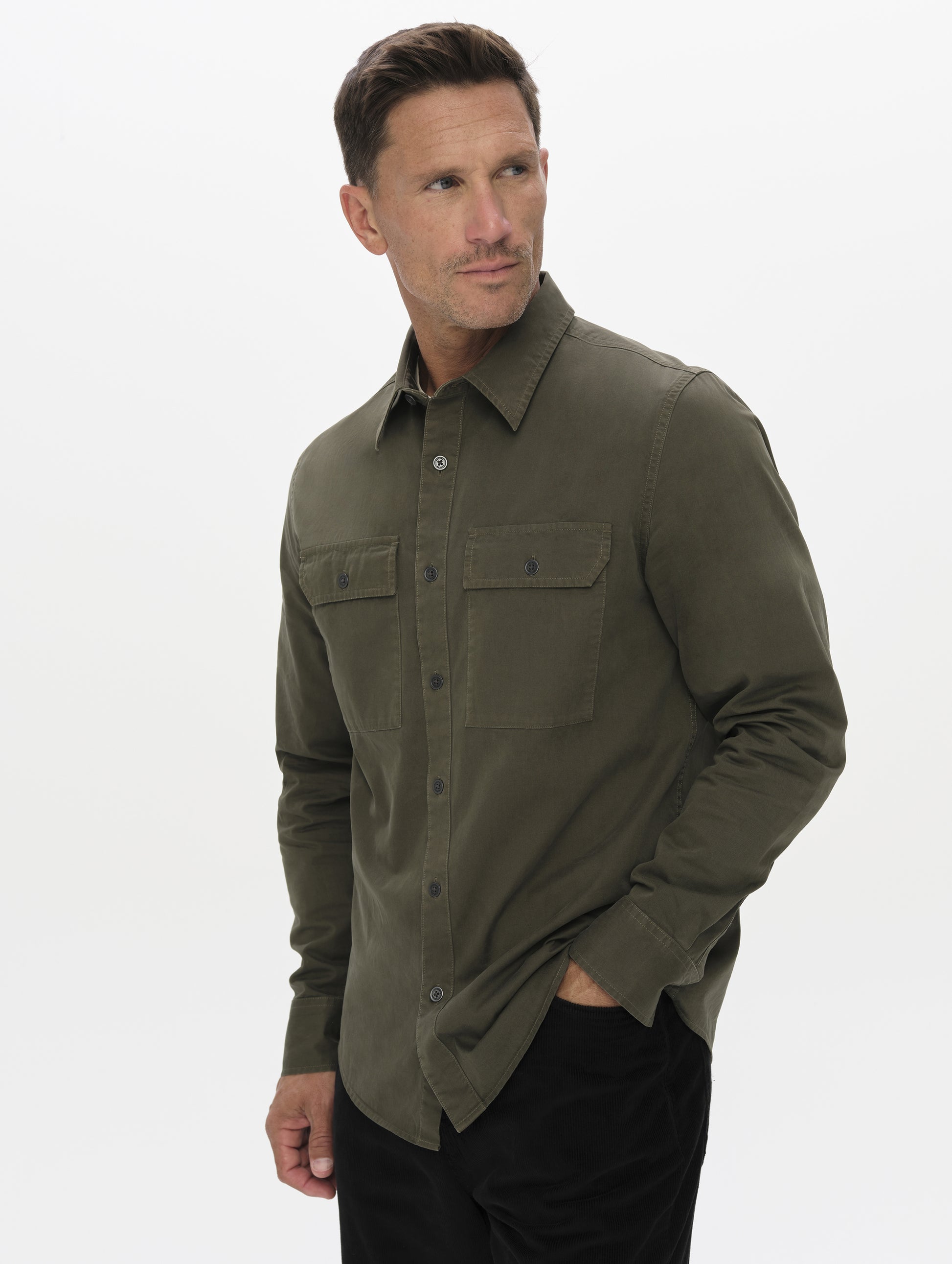 Front angled upper-body view of man wearing the Caden Work Shirt in Forest Green from AETHER Apparel.