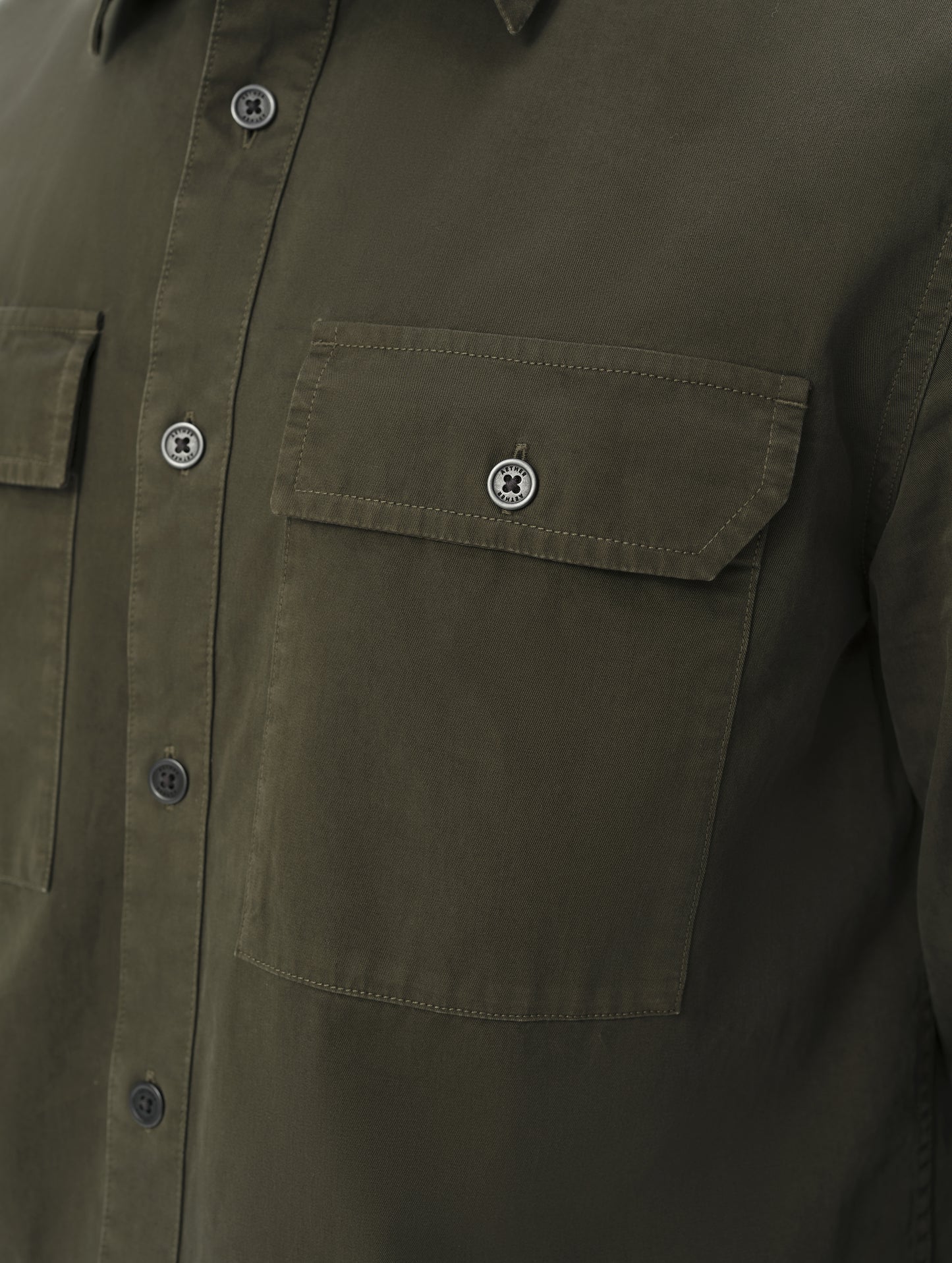 Closeup detailed view of the main center-front button closure and chest pockets on the Caden Work Shirt in Forest Green from AETHER Apparel.
