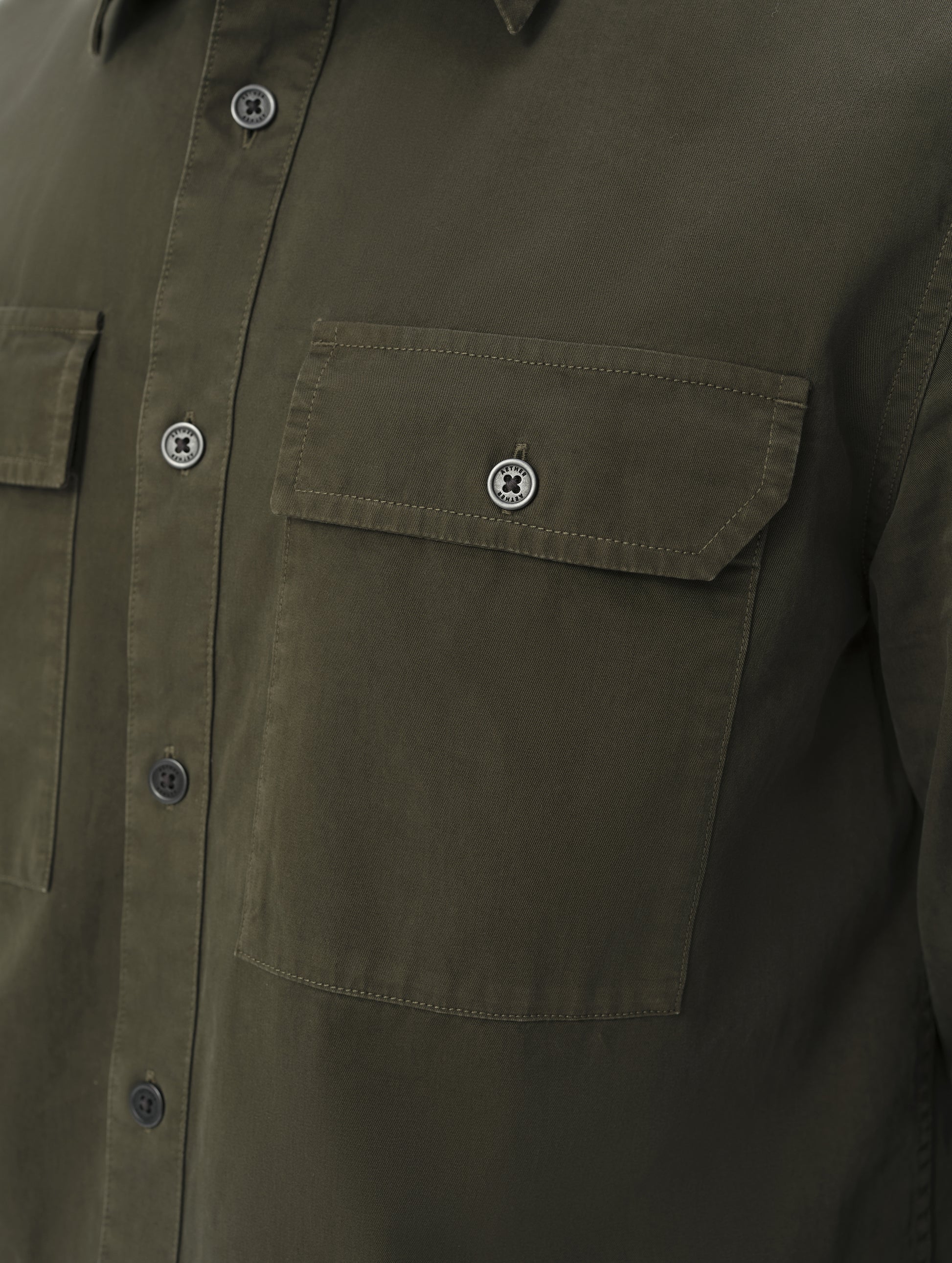 Closeup detailed view of the main center-front button closure and chest pockets on the Caden Work Shirt in Forest Green from AETHER Apparel.