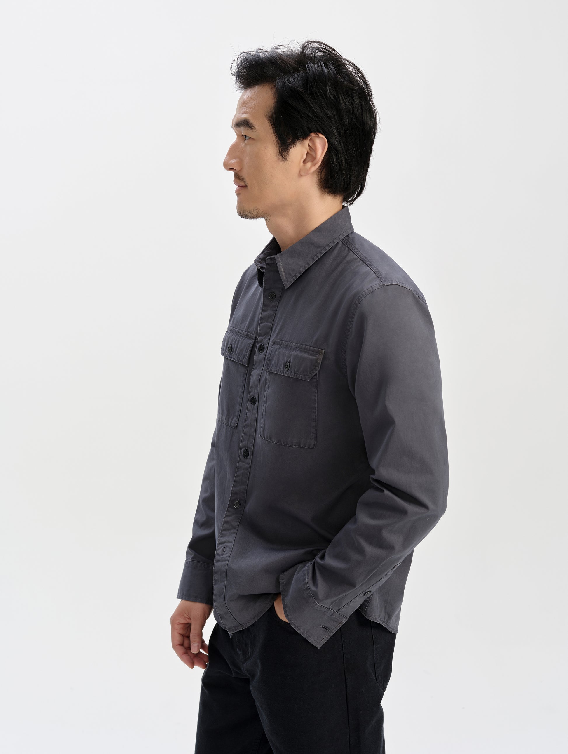 Side profile upper-body view of man wearing the Caden Work Shirt in Graphite from AETHER Apparel.