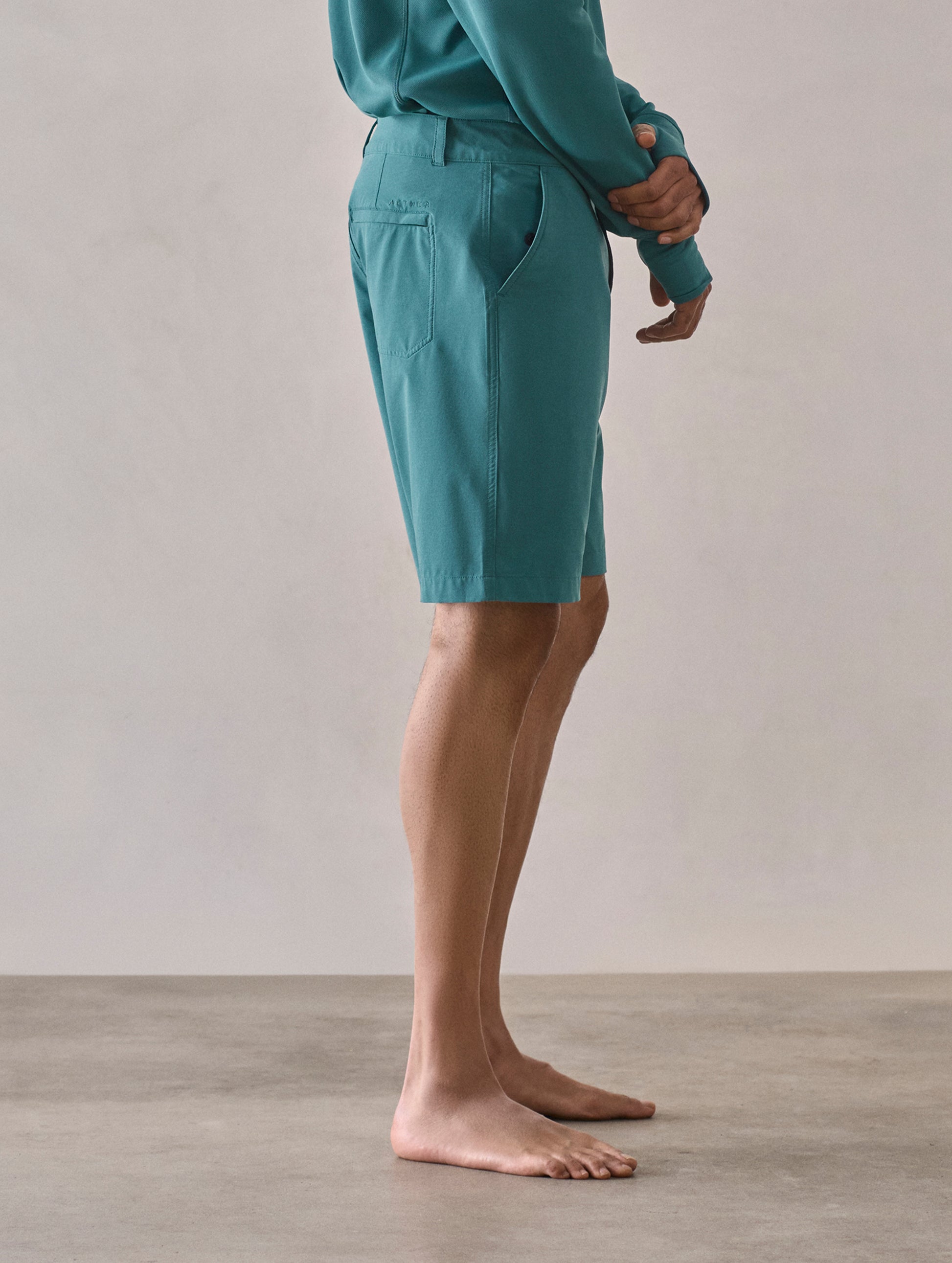 Side profile lower-body view of man wearing Catalina Submersible Short in Aqua Blue from AETHER Apparel.
