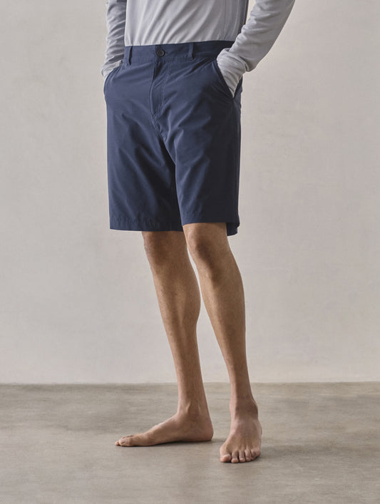 Front 3/4 lower-body view of man wearing Catalina Submersible Short in Total Eclipse dark blue from AETHER Apparel.