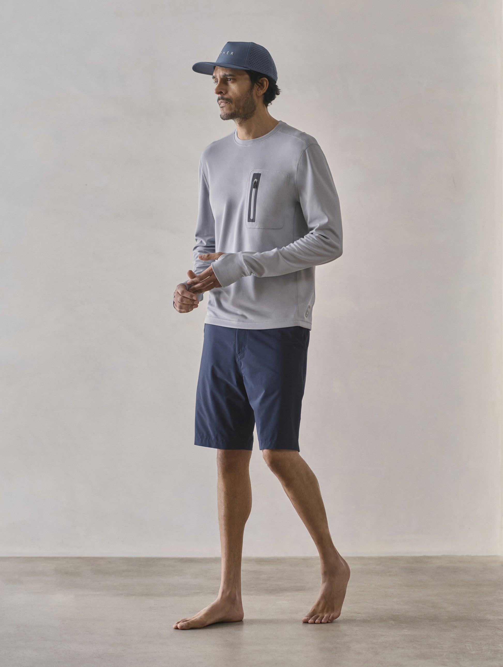 Front 3/4 full-body view of man wearing Catalina Submersible Short in Total Eclipse dark blue from AETHER Apparel.