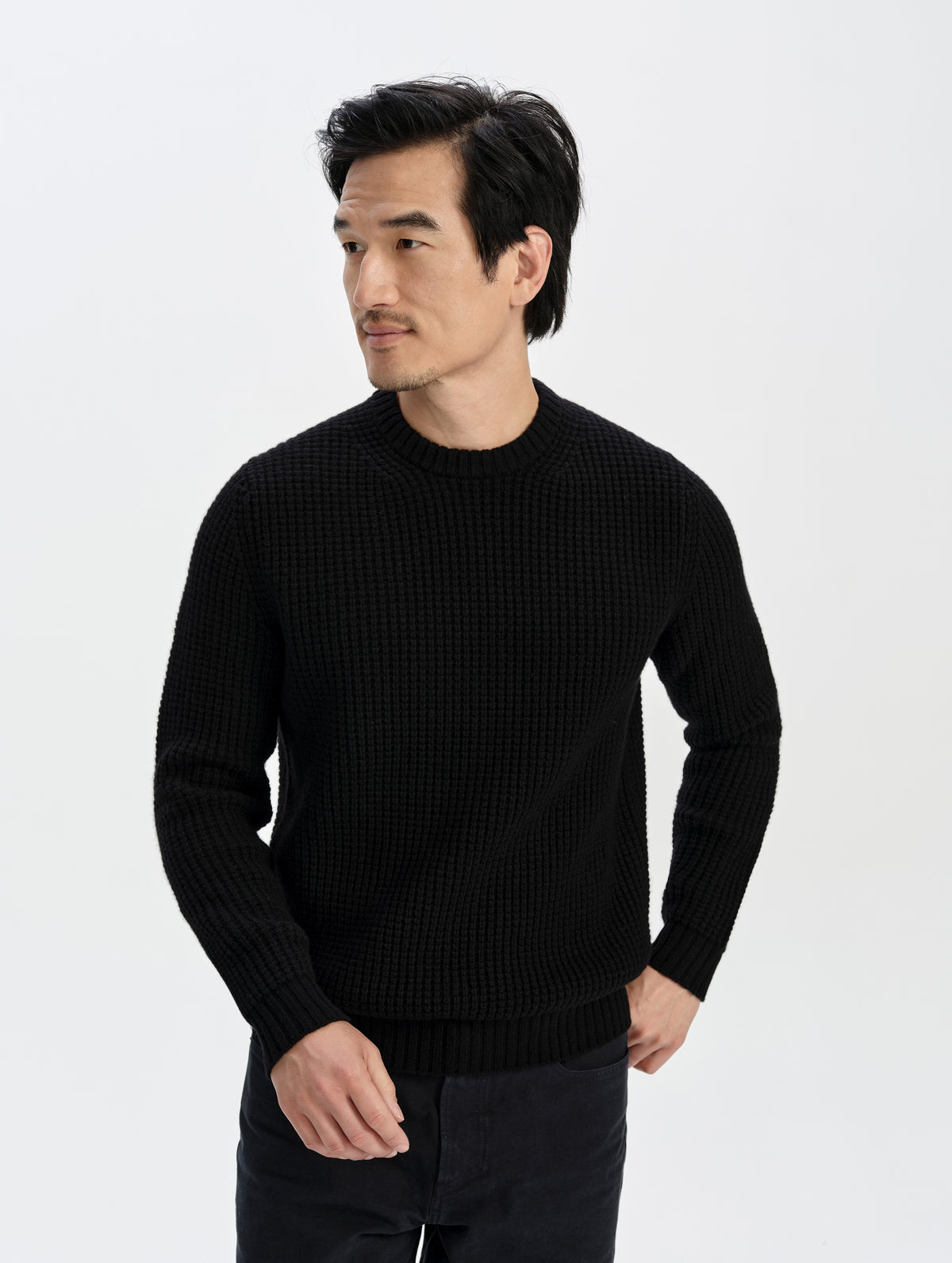 Front upper-body view of man wearing the Coastal Waffle Sweater in Onyx Black from AETHER Apparel.