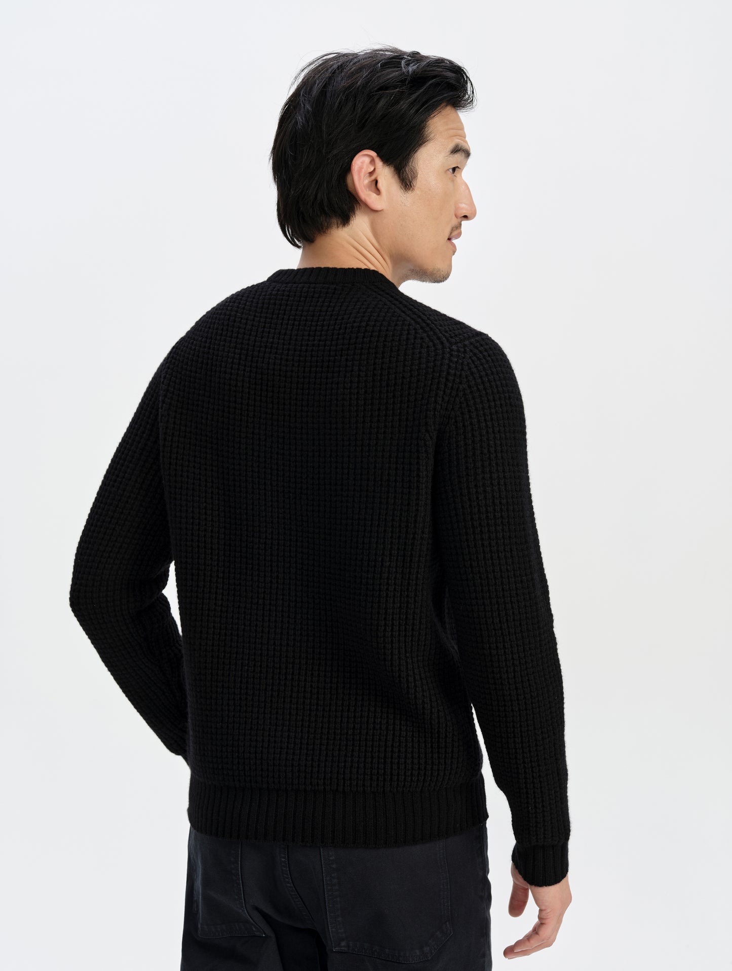 Rear upper-body view of man wearing the Coastal Waffle Sweater in Onyx Black from AETHER Apparel.