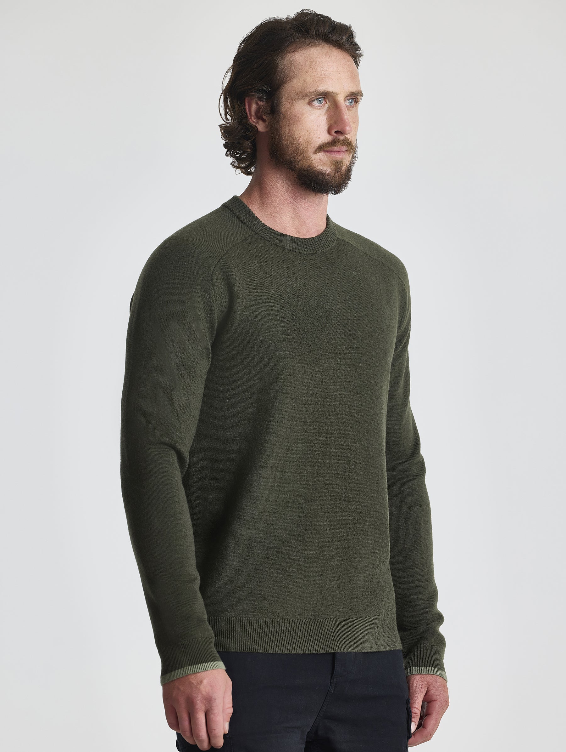 Angled view of man wearing Corbin Sweater in Forest Green from AETHER Apparel.