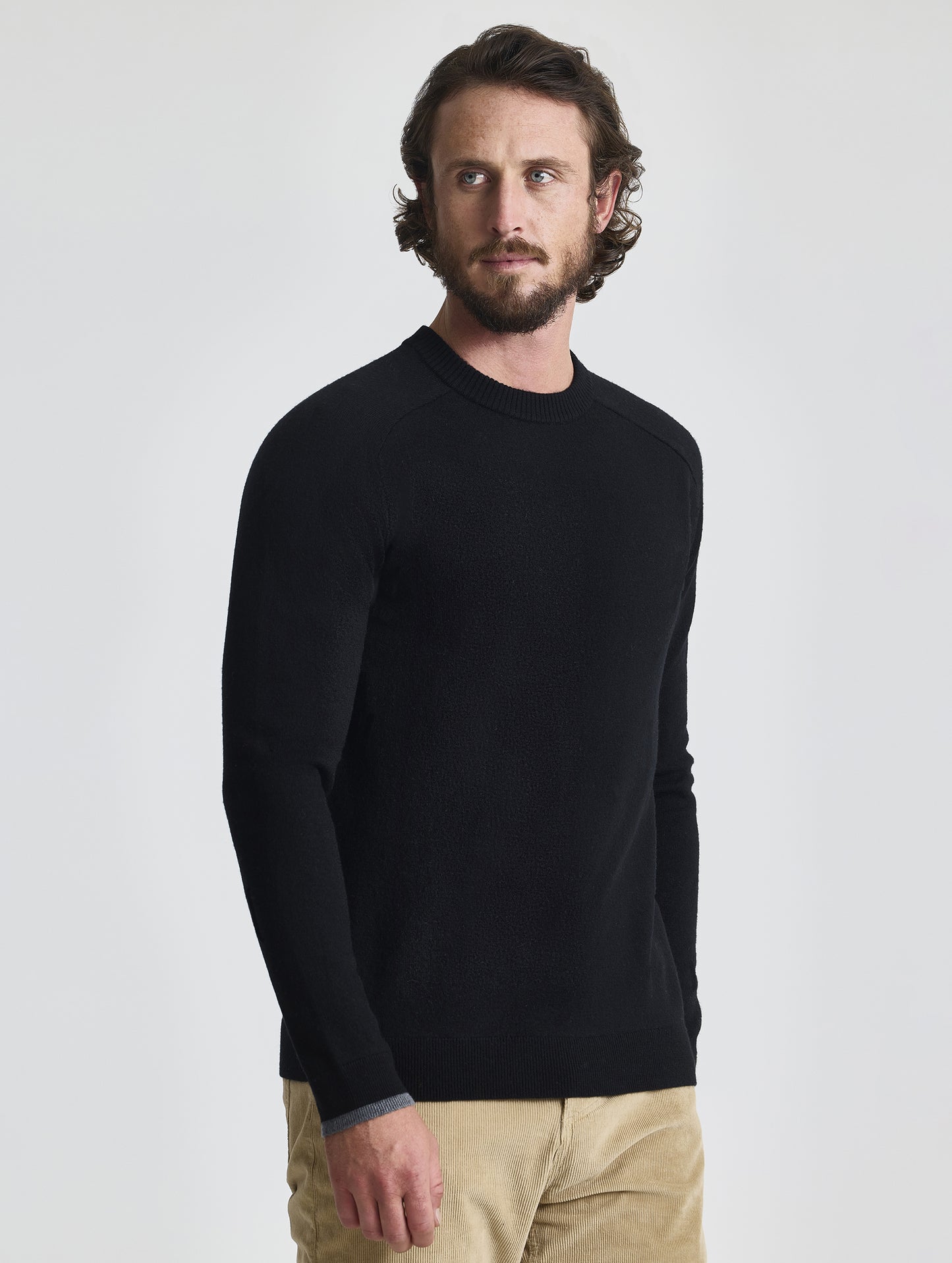 Angled front view of man wearing Corbin Sweater in Onyx Black from AETHER Apparel. 