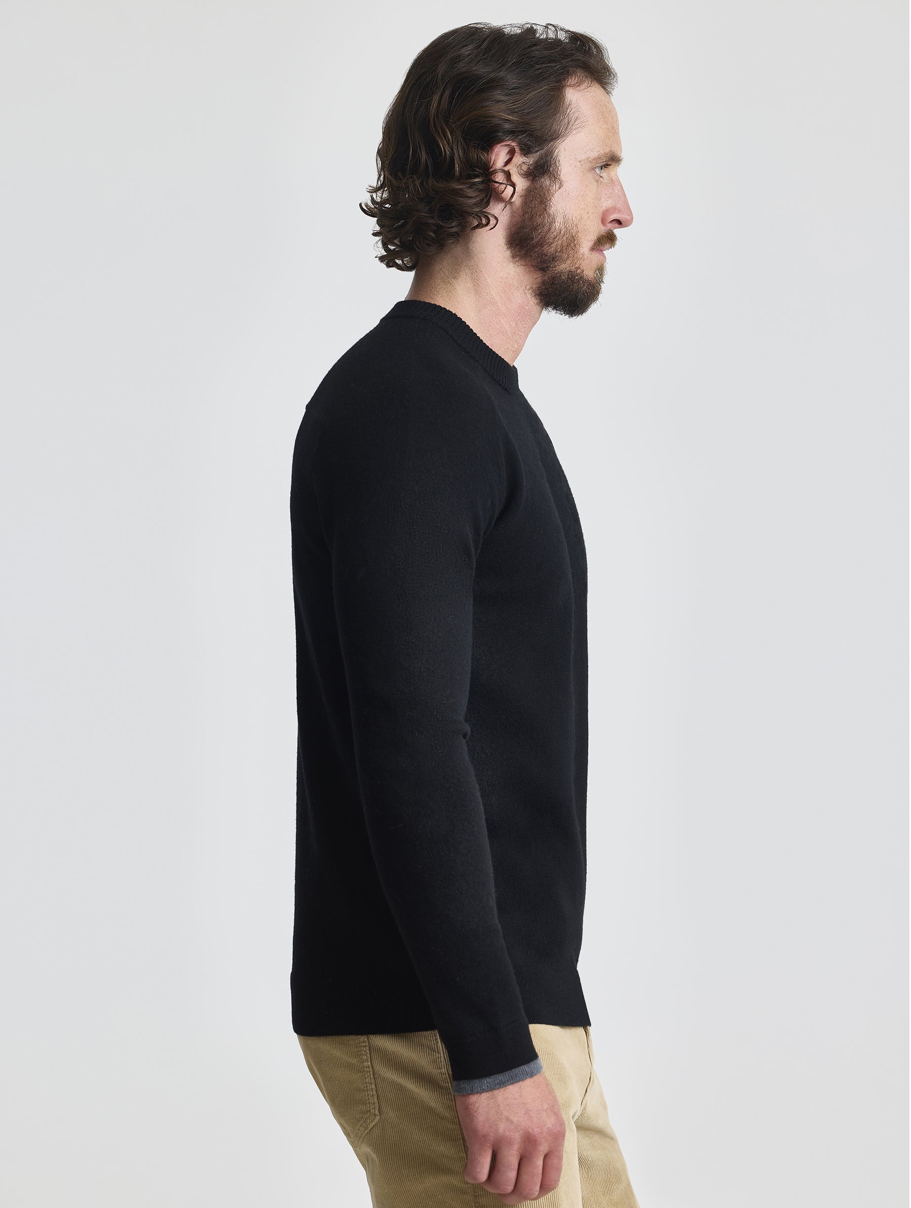 Right profile view of man wearing Corbin Sweater in Onyx Black from AETHER Apparel. 