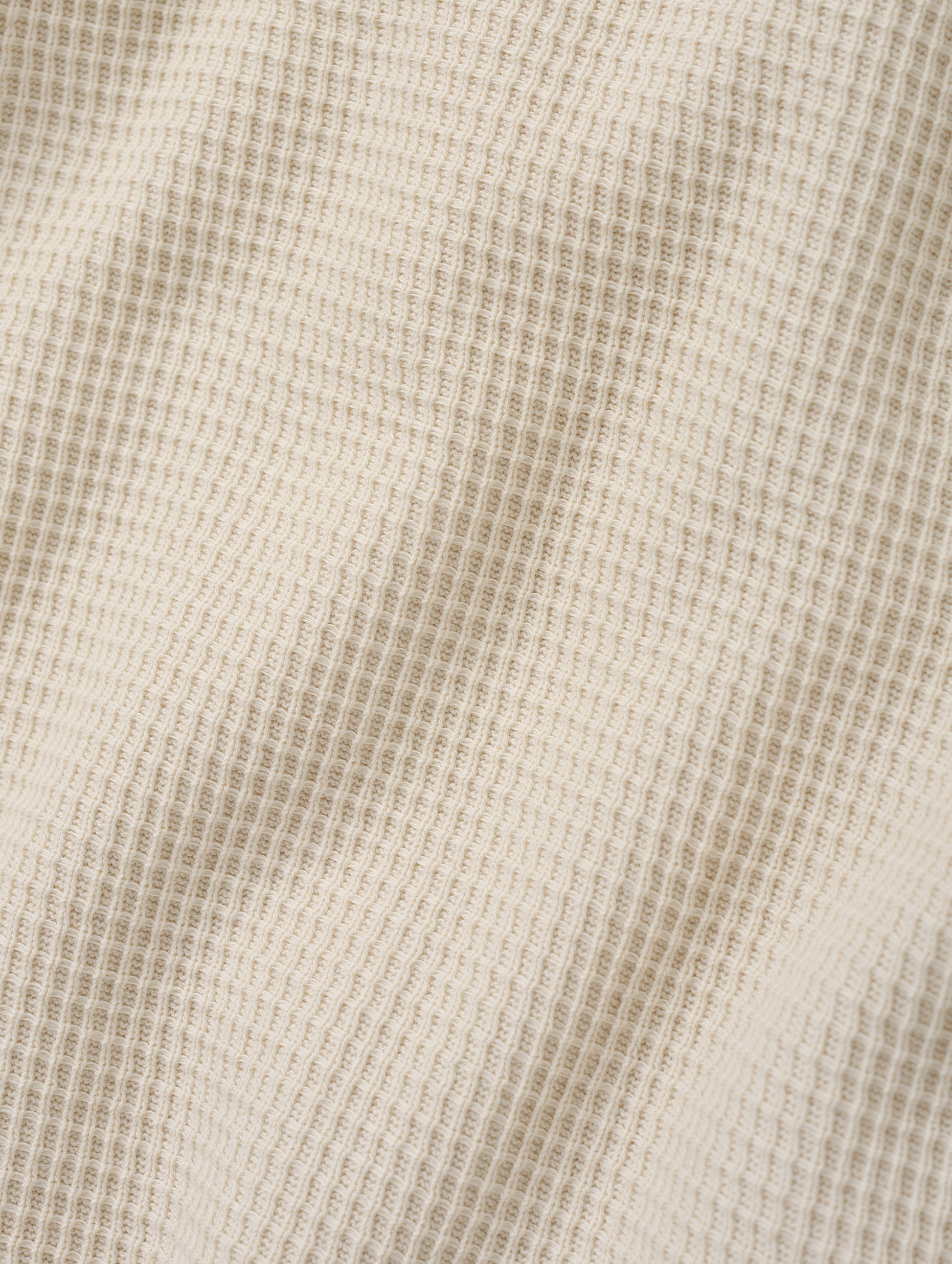 Closeup detailed view of the cotton double-weave waffle fabric on the Daley Waffle Henley in Bone from AETHER Apparel.