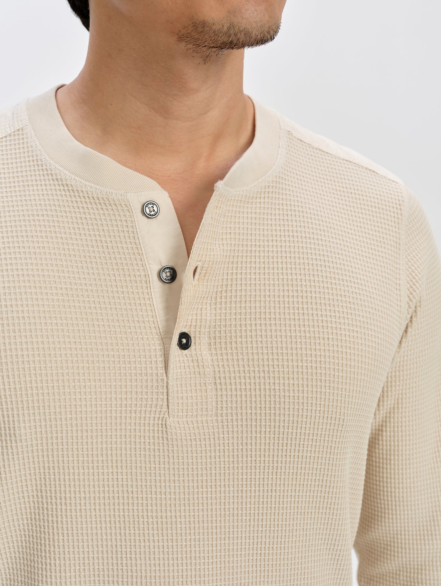Closeup detailed view of the henley buttons on the Daley Waffle Henley in Bone from AETHER Apparel.