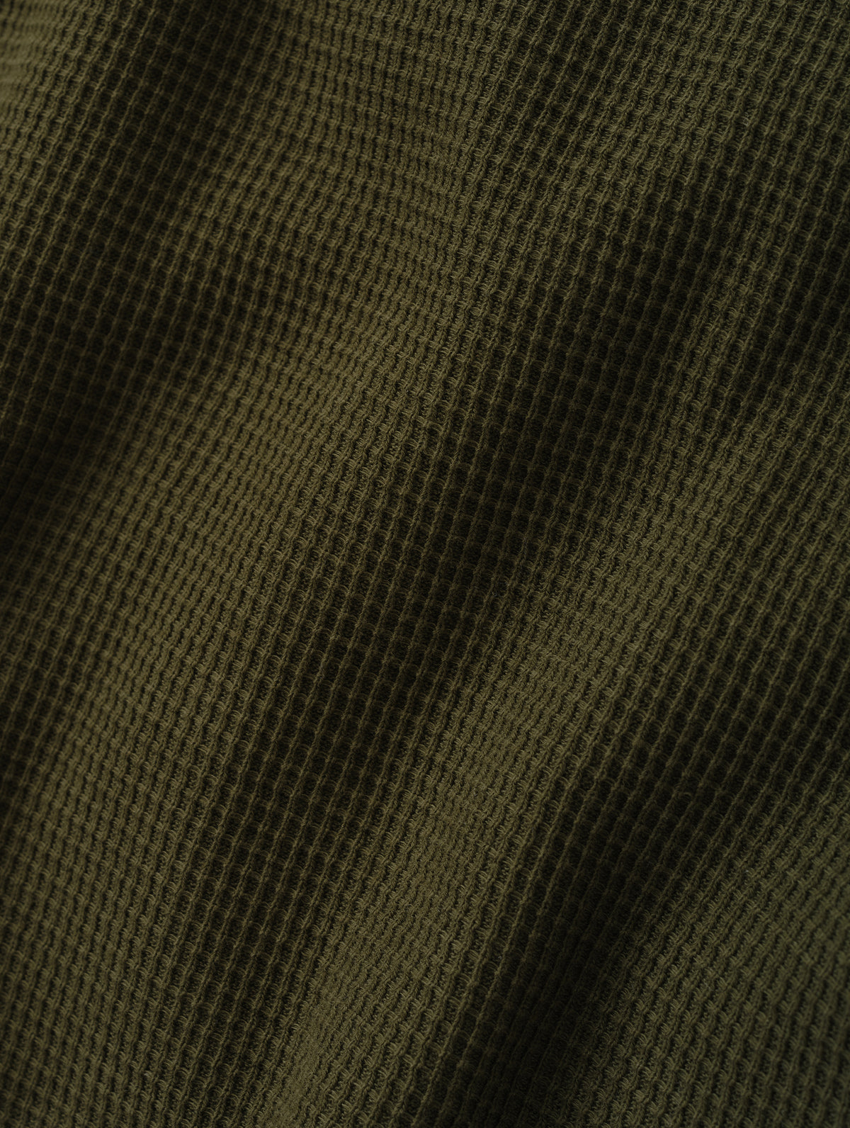 Closeup detailed view of the cotton double-weave waffle fabric on the Daley Waffle Henley in Forest Green from AETHER Apparel.
