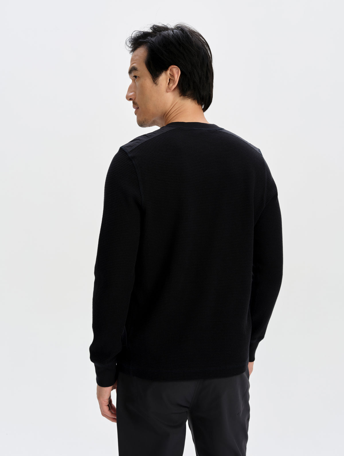 Rear upper-body view of man wearing the Daley Waffle Henley in Onyx Black from AETHER Apparel.