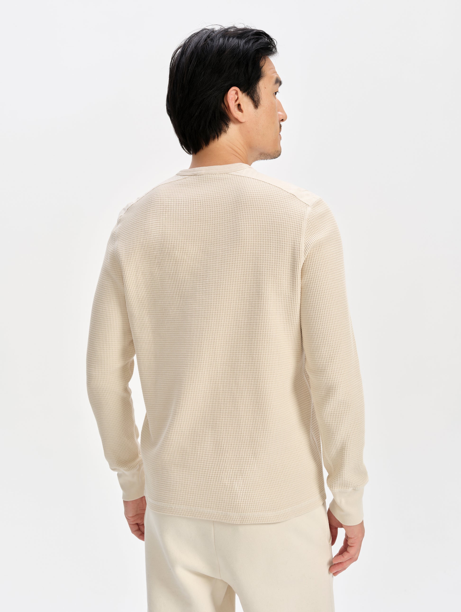 Rear 3/4 upper-body view of man wearing the Daley Waffle Shirt in Bone from AETHER Apparel.