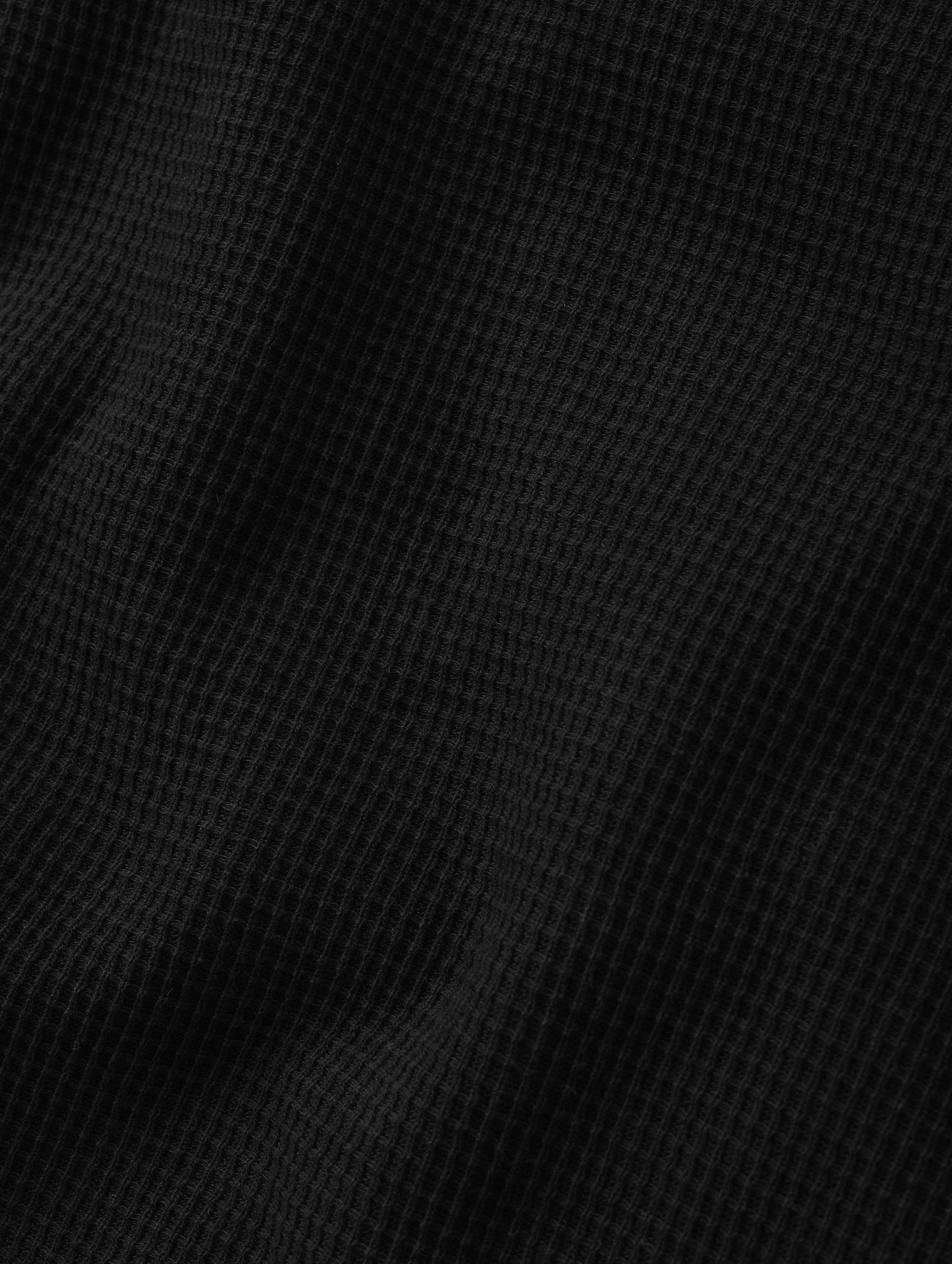 Closeup detailed view of the cotton double-weave waffle fabric on the Daley Waffle Shirt in Onyx Black from AETHER Apparel.