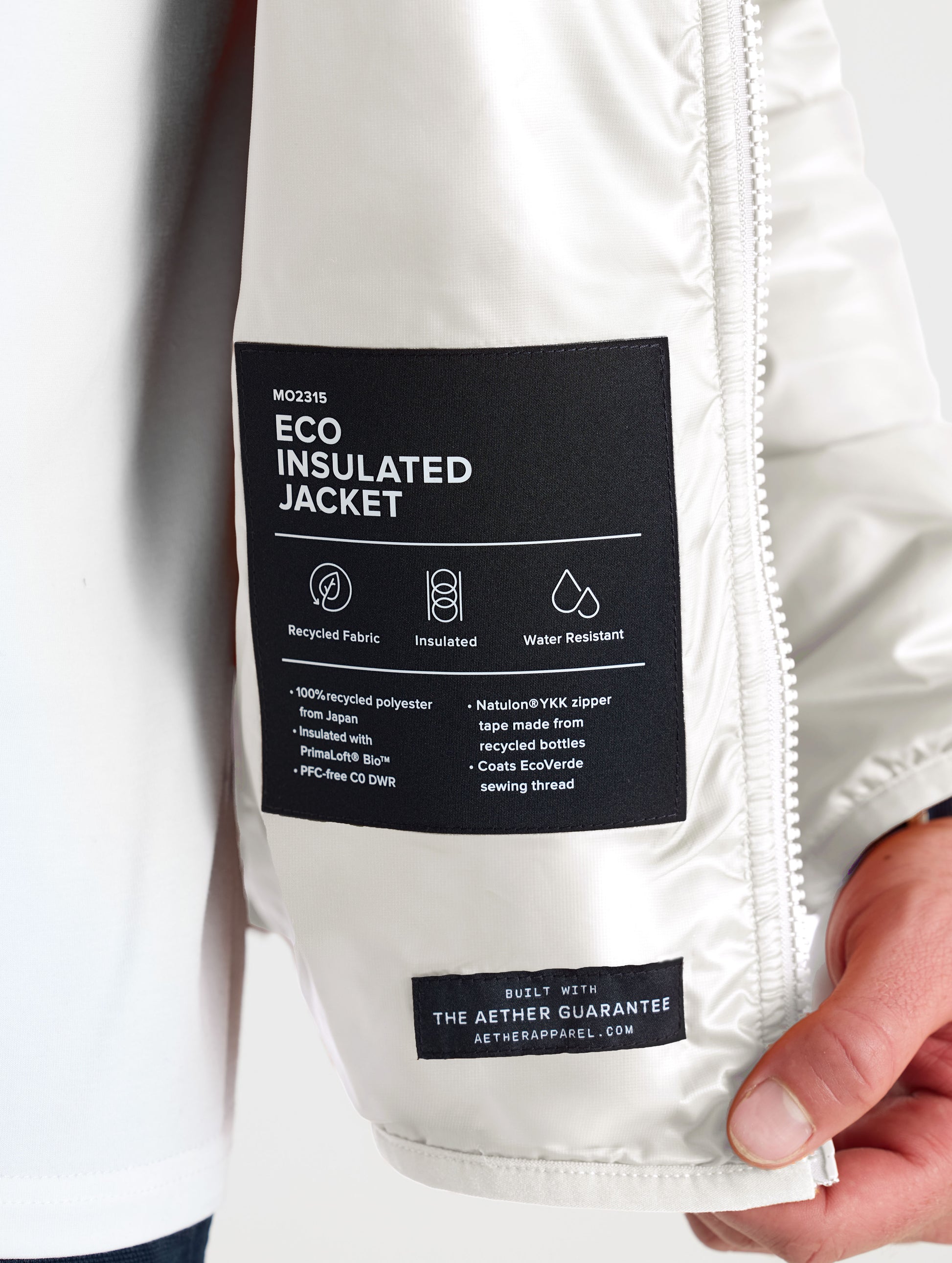Closeup view of wearer's left interior label of Eco Insulated Jacket in Bone white from AETHER Apparel.