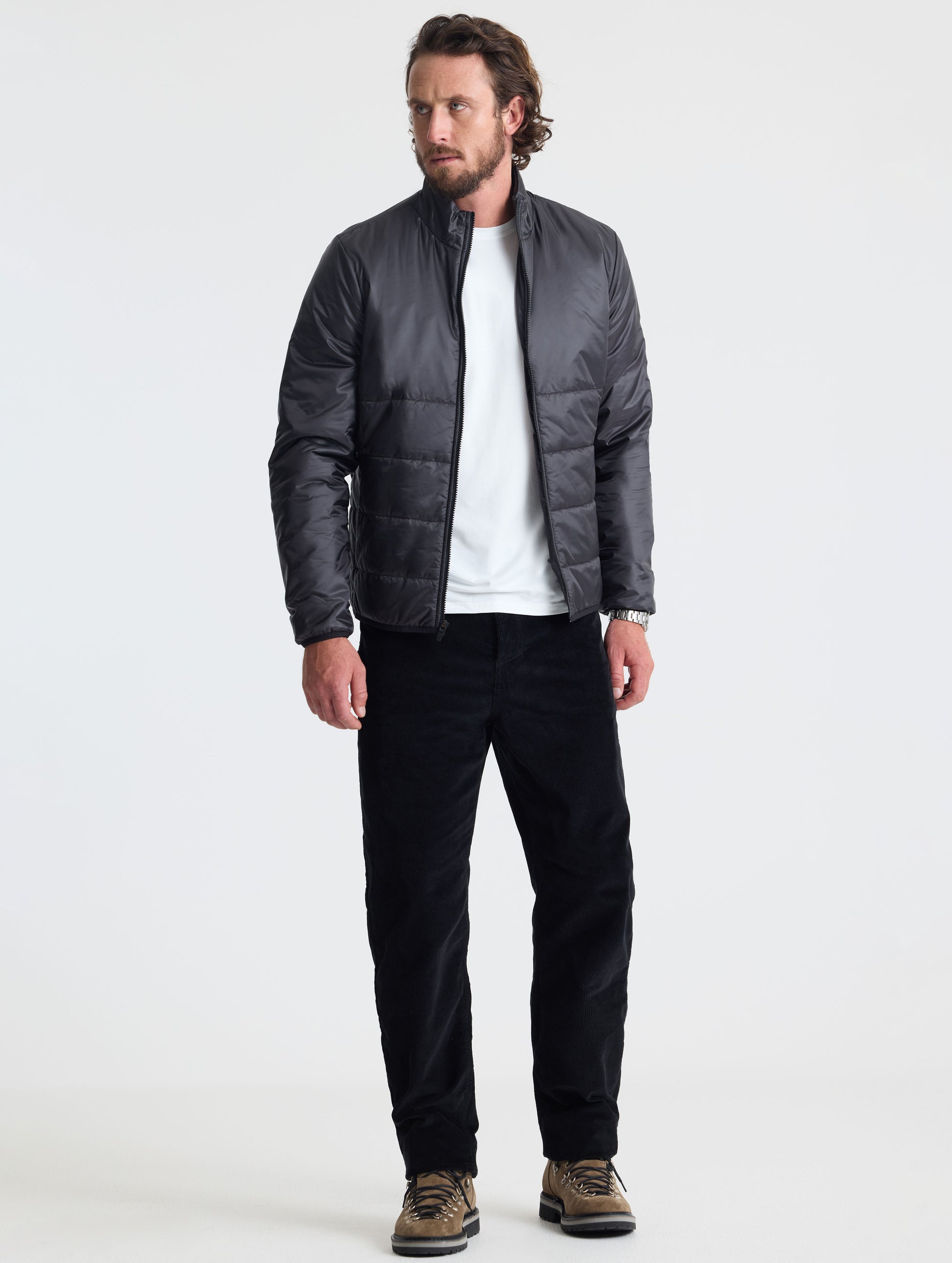 Full body view of man wearing Eco Insulated Jacket in Onyx Black from AETHER Apparel.
