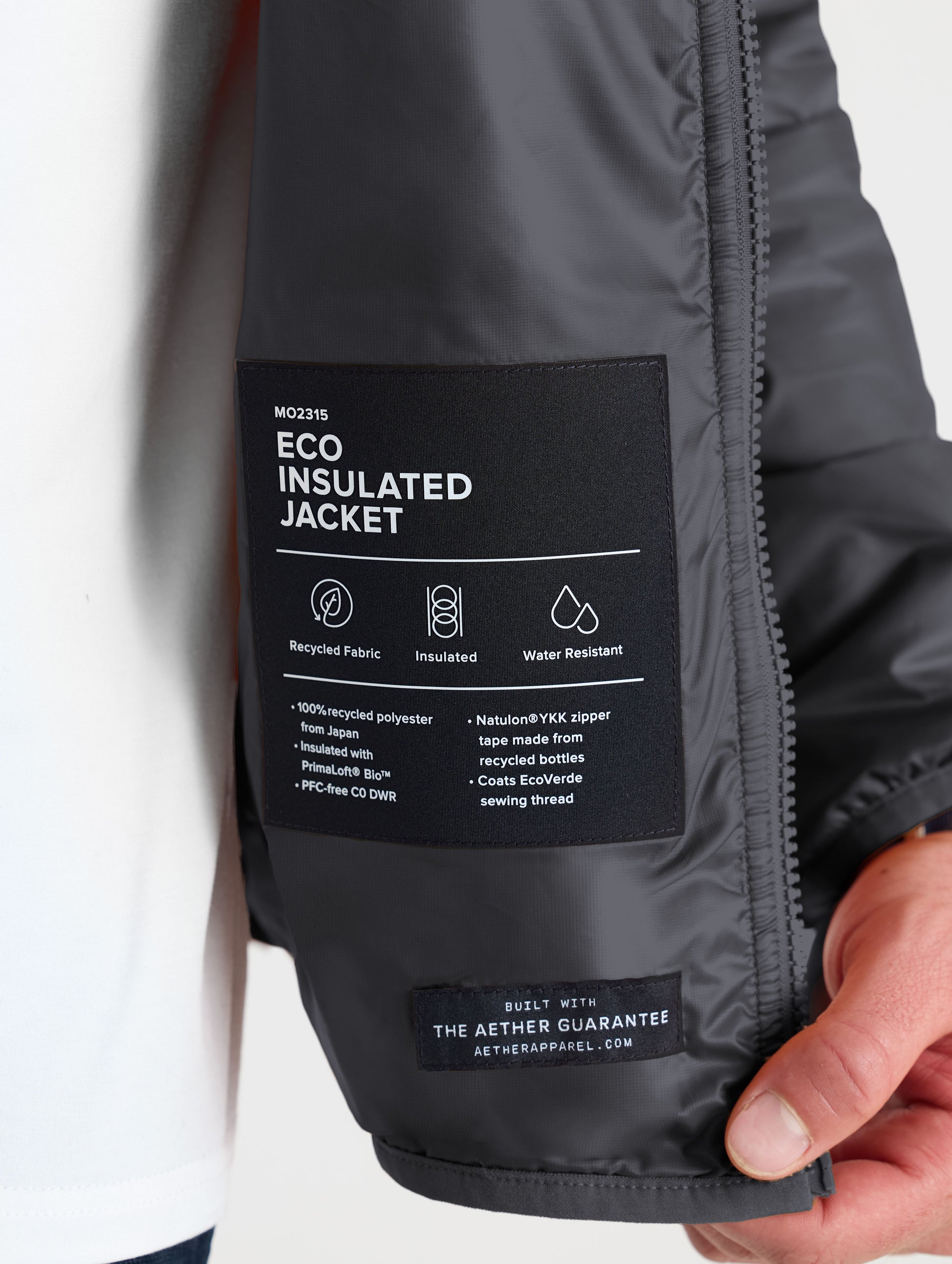 Closeup view of wearer's left interior label of Eco Insulated Jacket in Onyx Black from AETHER Apparel.