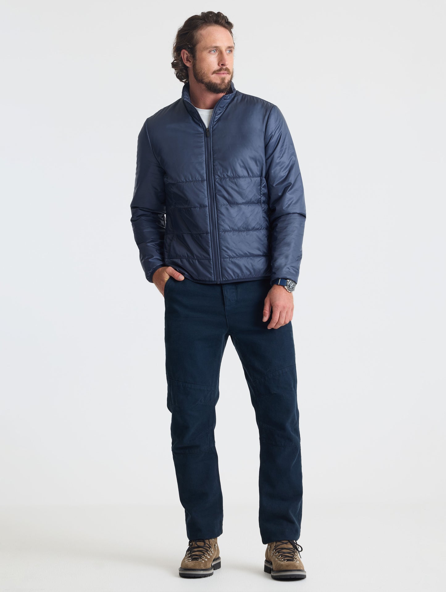 Full body view of man wearing Eco Insulated Jacket in Total Eclipse dark blue from AETHER Apparel.