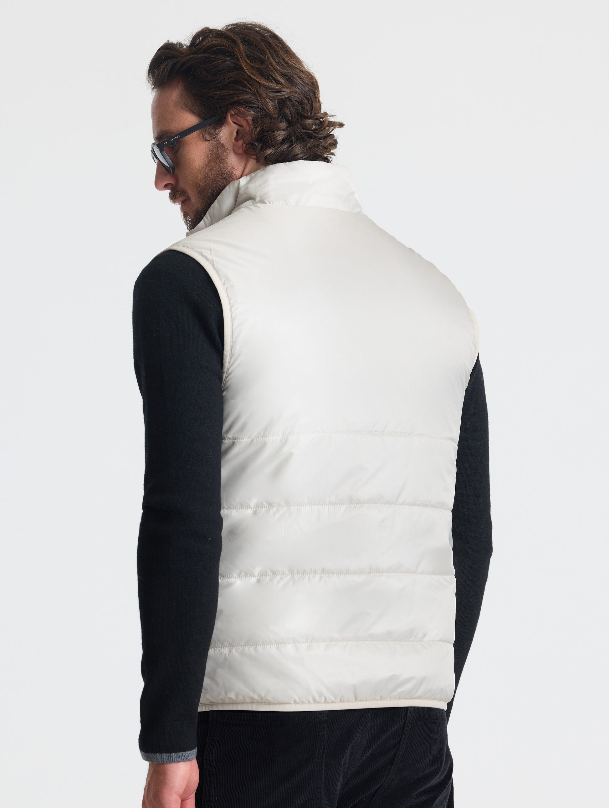 Rear view of man wearing Eco Insulated Vest in Bone white from AETHER Apparel.
