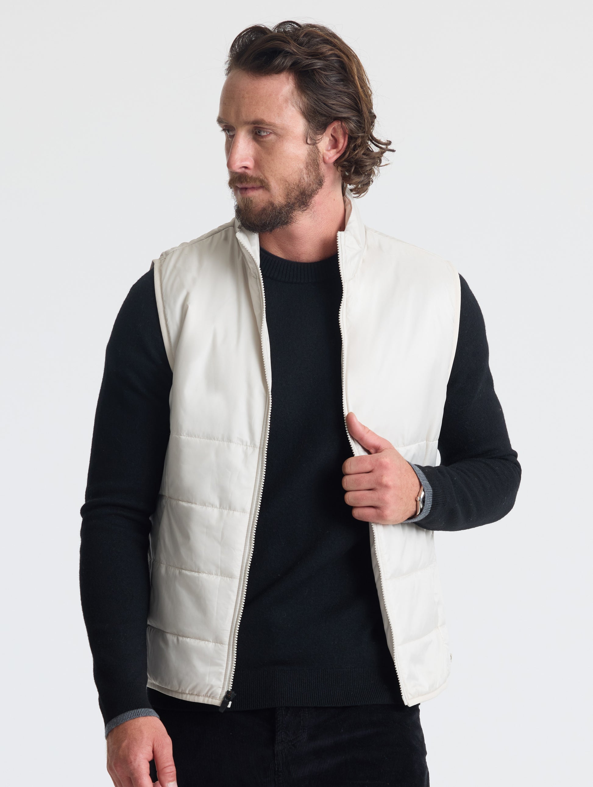 Front view of man wearing unzipped Eco Insulated Vest in Bone white from AETHER Apparel.