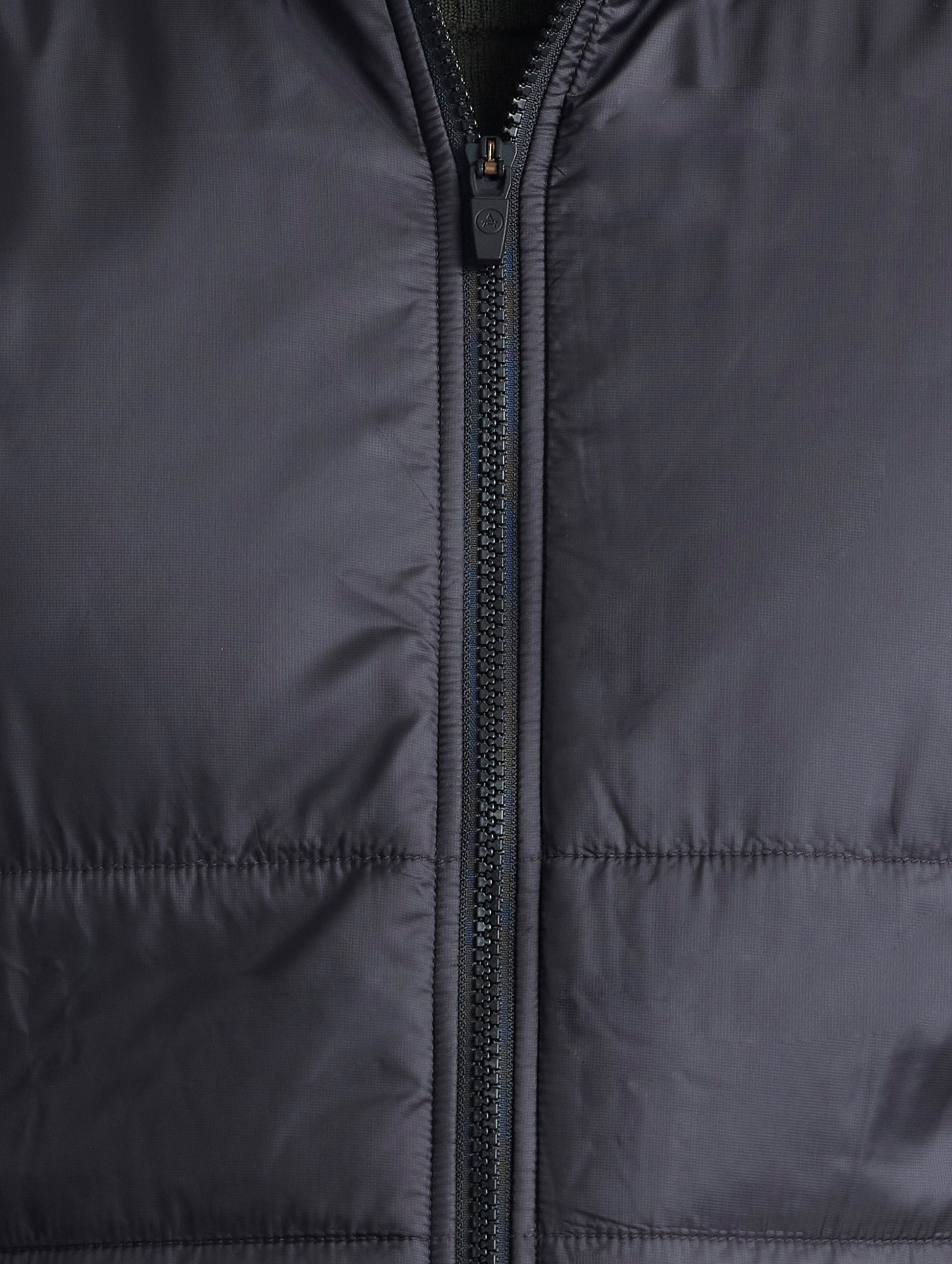Closeup view of center zipper of Eco Insulated Vest in Onyx Black from AETHER Apparel.