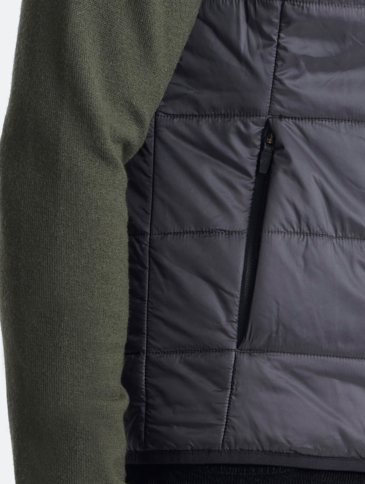 Closeup view of wearer's right hand pocket of Eco Insulated Vest in Onyx Black from AETHER Apparel.