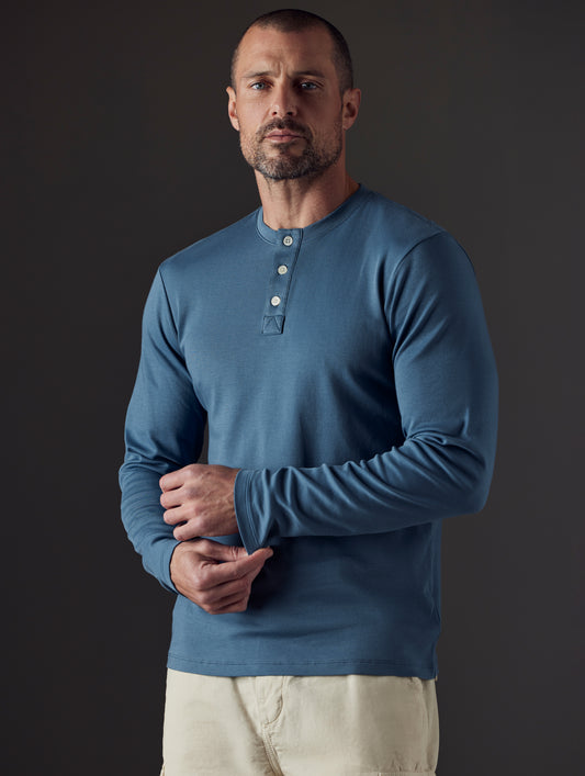 Man wearing blue organic cotton henley from AETHER Apparel
