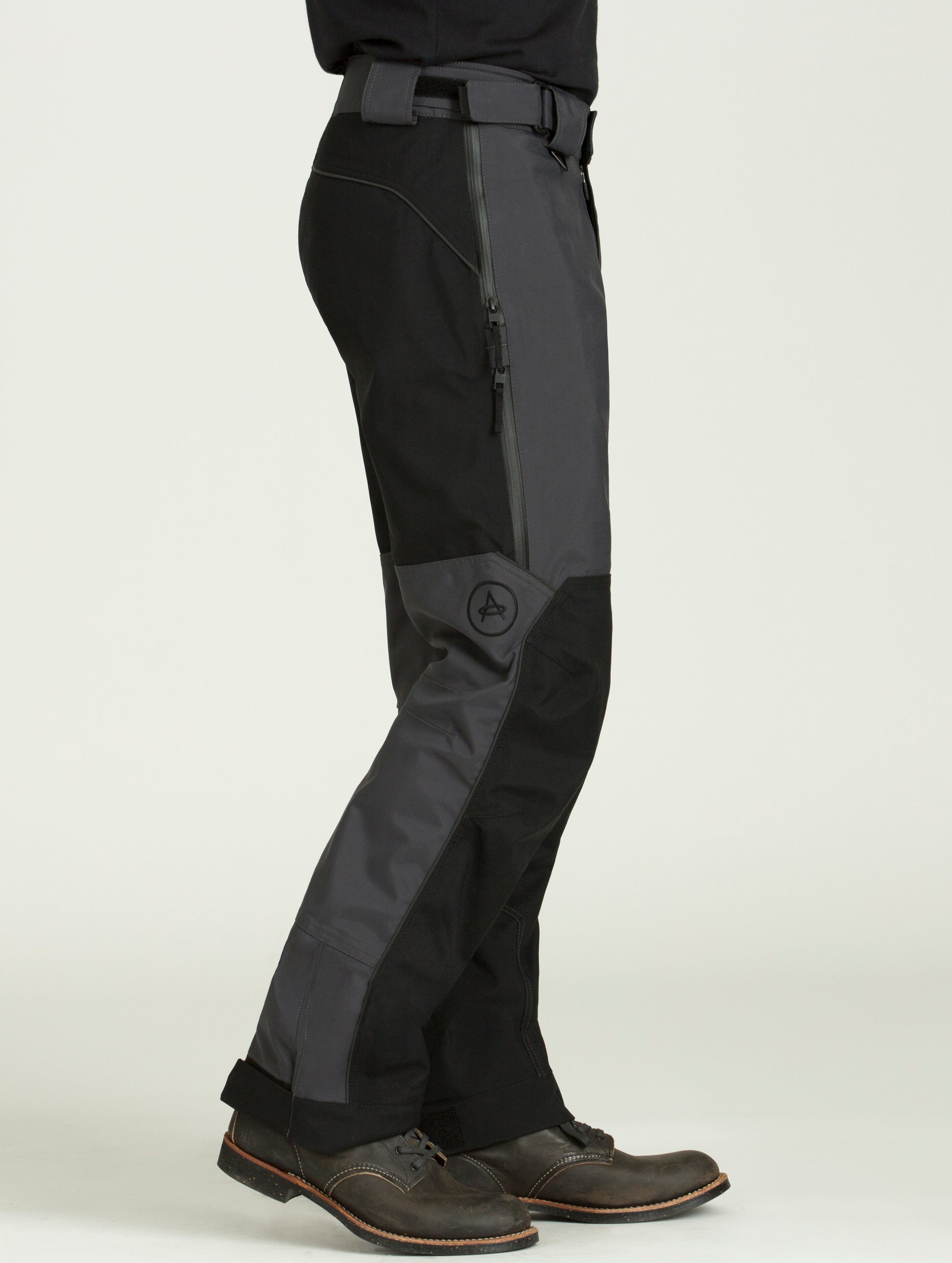 Side view of man wearing dark grey Expedition Motorcycle Pant from AETHER Apparel.