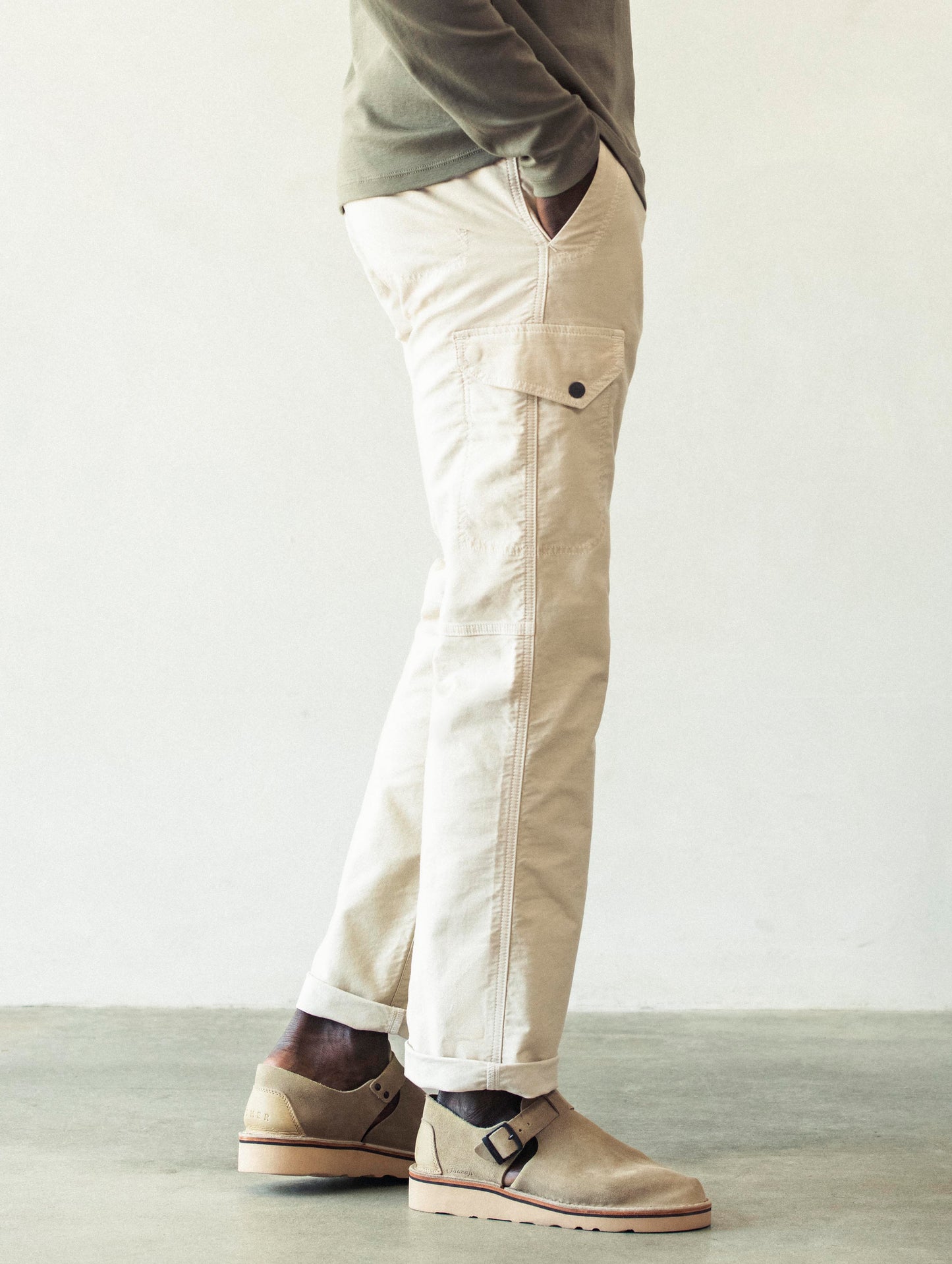 Right side profile lower body view of man wearing Fairfax Pant 2.0 in Bone white from AETHER Apparel.