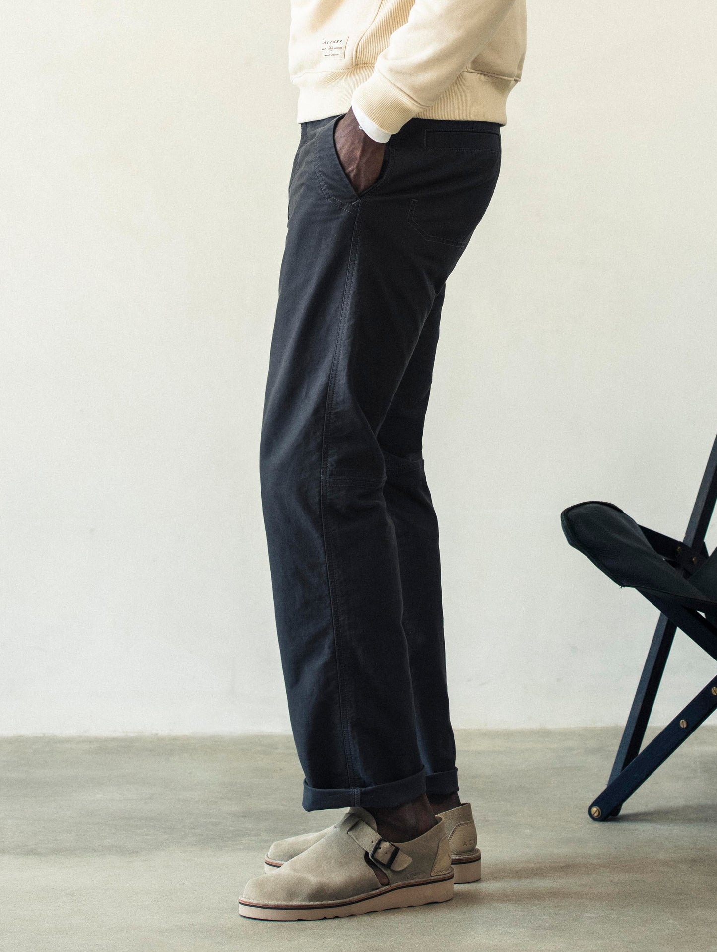 Left lower body view of man wearing Fairfax Pant 2.0 in Graphite from AETHER Apparel.