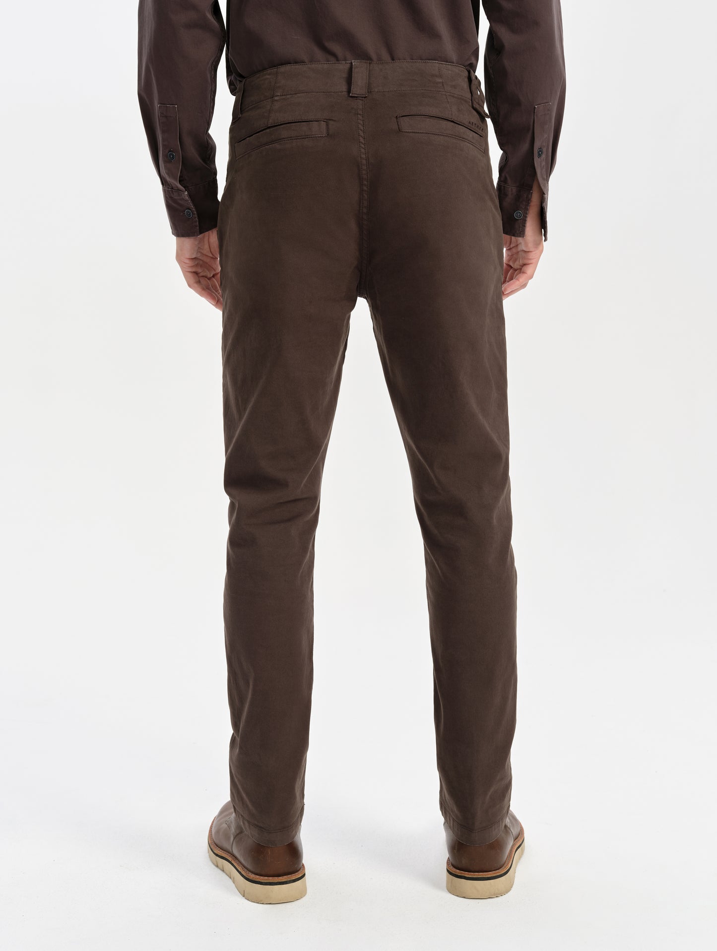 Rear lower-body view of man wearing the Flint Chino Pant in Ash Brown from AETHER Apparel.
